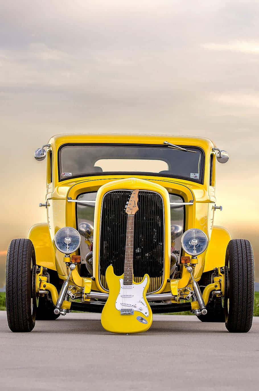 A Yellow Car With A Guitar In Front Of It Wallpaper