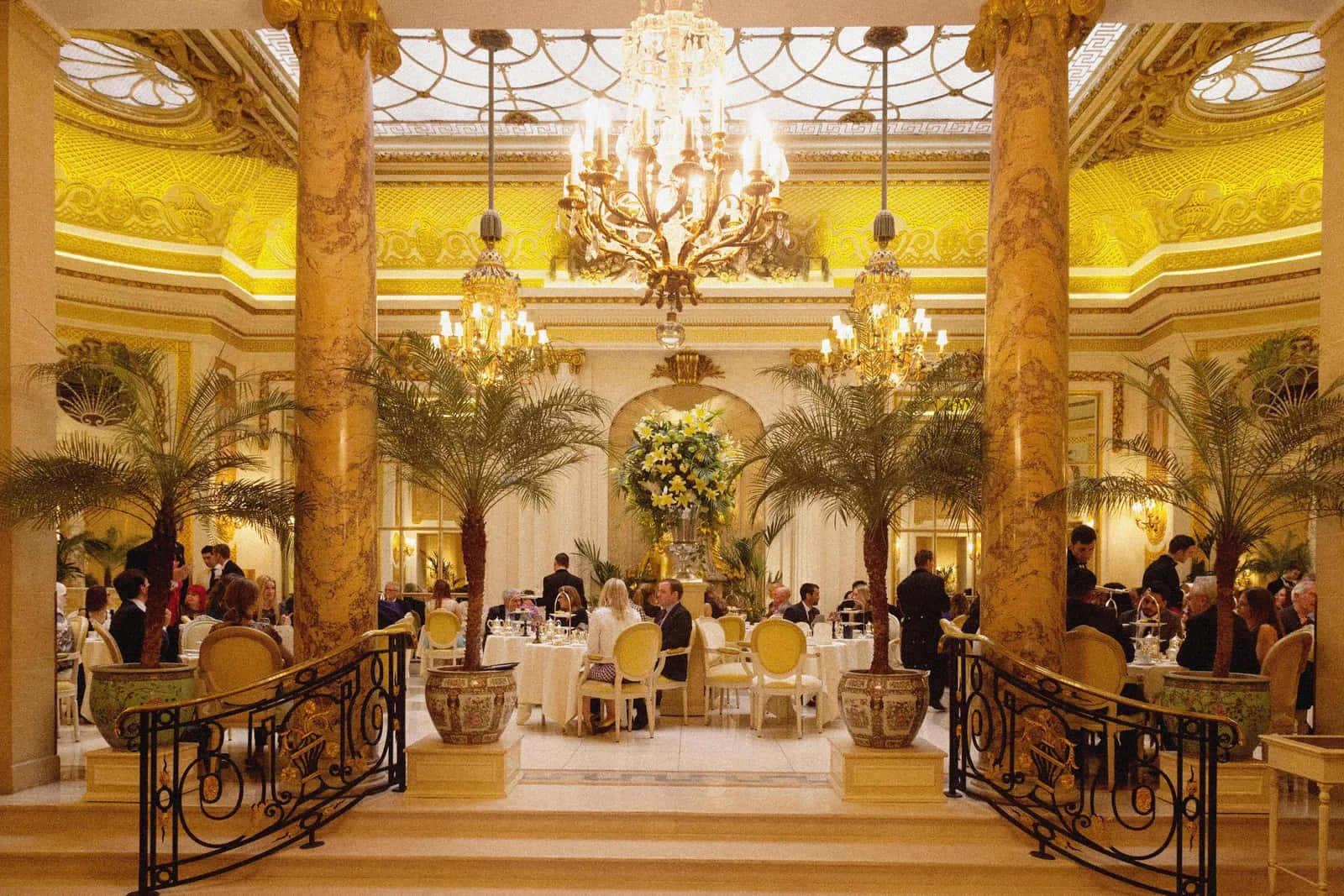 A Large Dining Room With A Chandelier And People