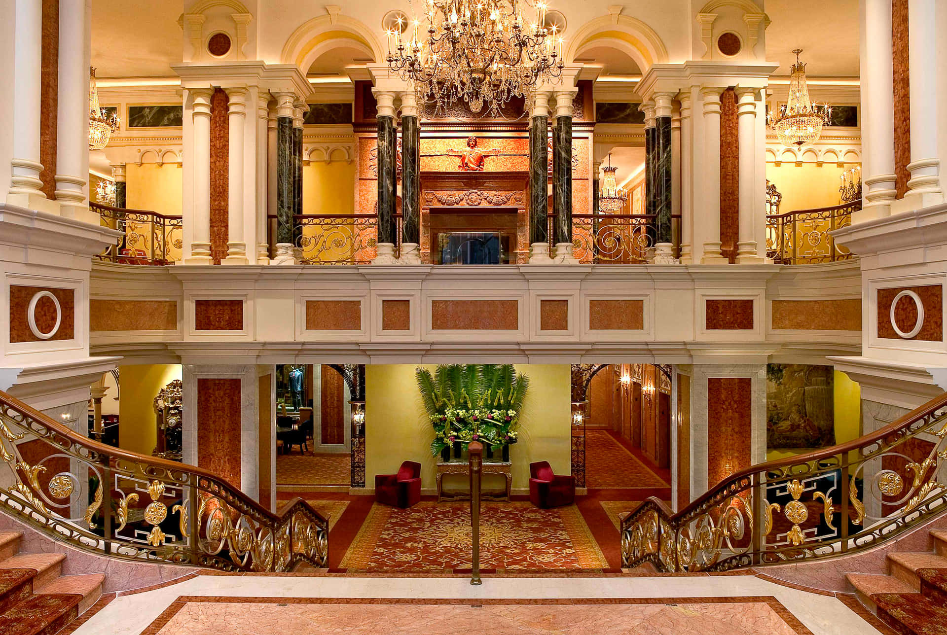 A Large Lobby With A Staircase And Chandelier