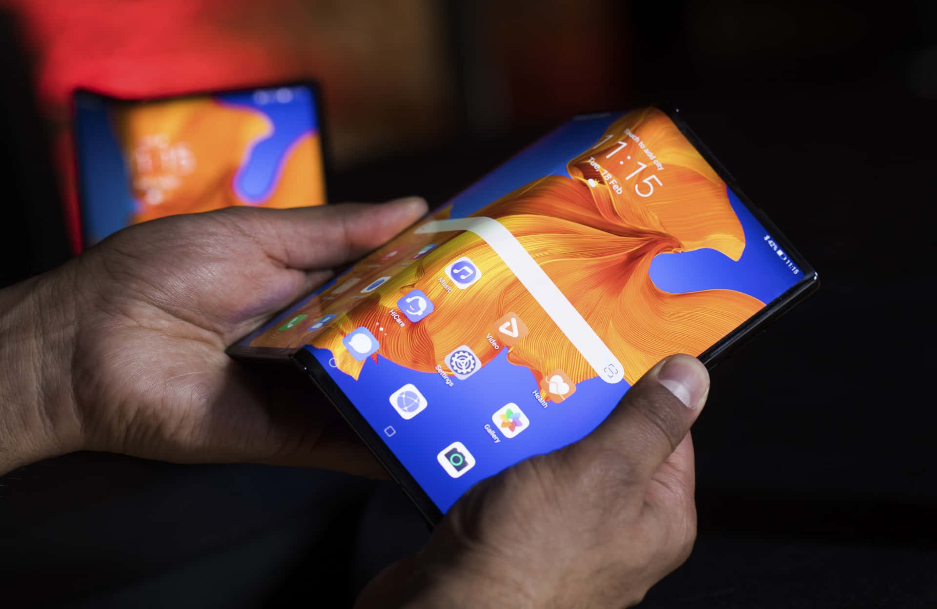 A Person Holding A Smartphone With A Foldable Screen