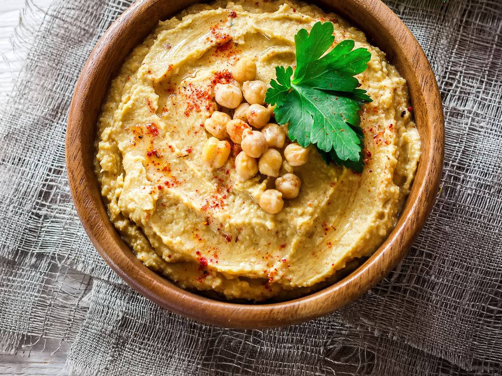 A wholesome plate of hummus sprinkled with paprika and garnished with chickpeas Wallpaper