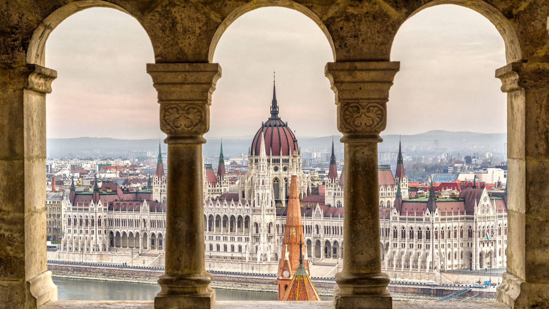 Unavista Del Edificio Del Parlamento Húngaro Desde Una Ventana Arqueada Fondo de pantalla