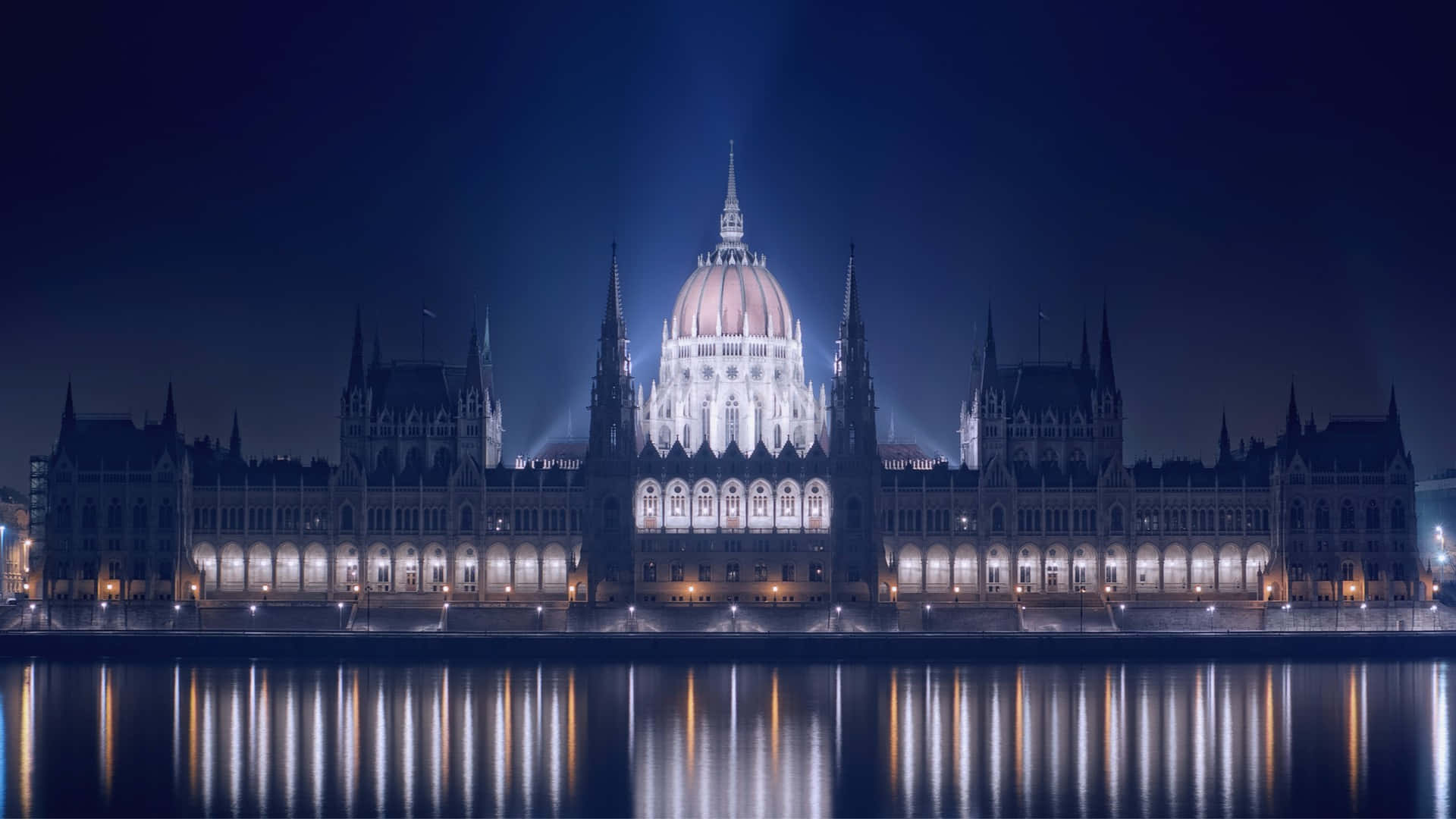 The Majestic Hungarian Parliament Building Illuminated By Night Wallpaper