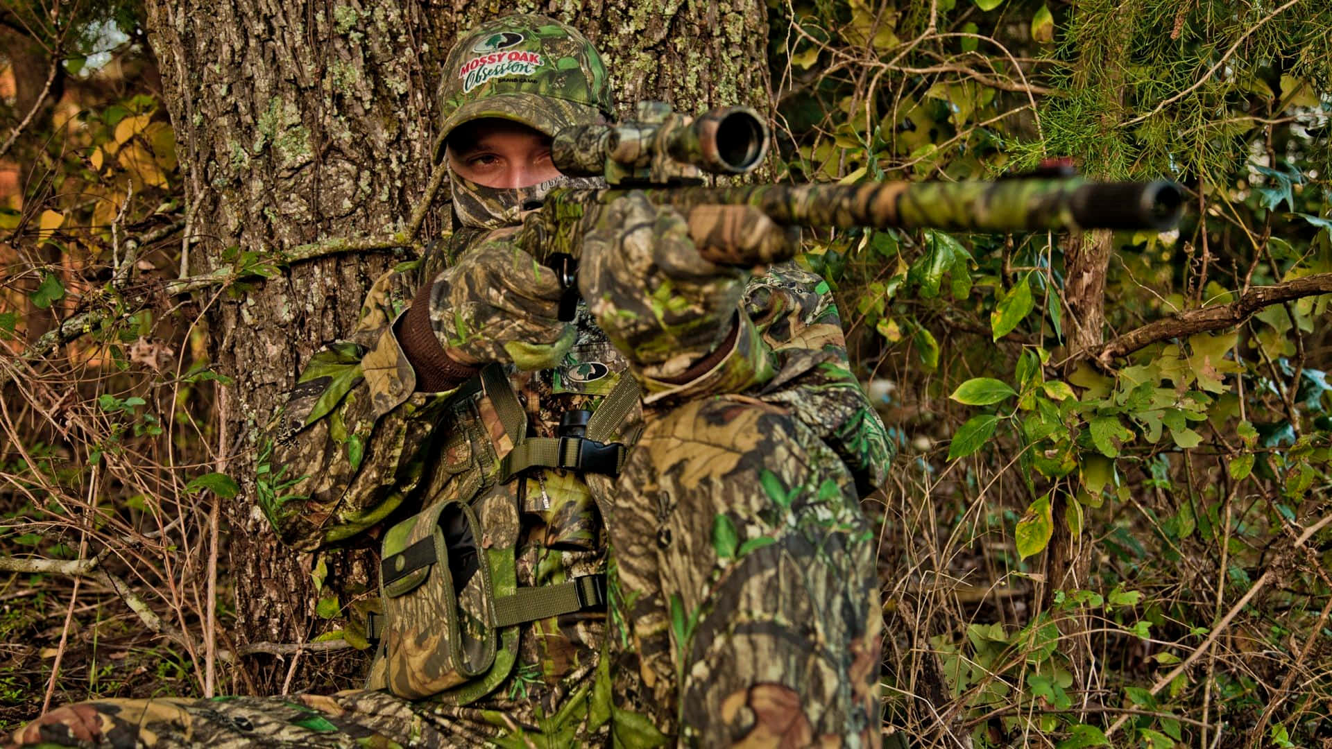 Hunting Camo Pointing A Gun Wallpaper