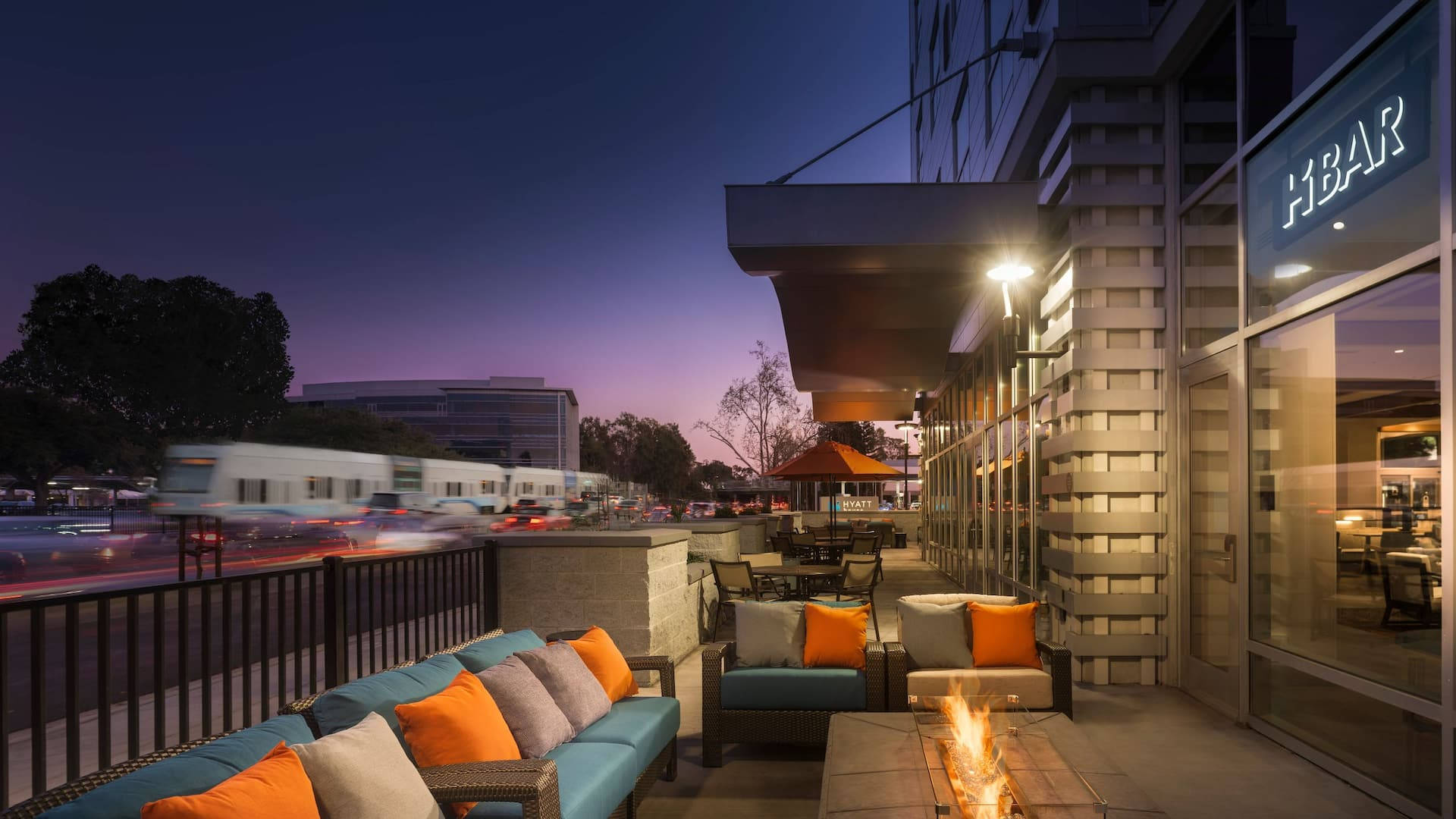 a patio with couches and fire pit at dusk Wallpaper