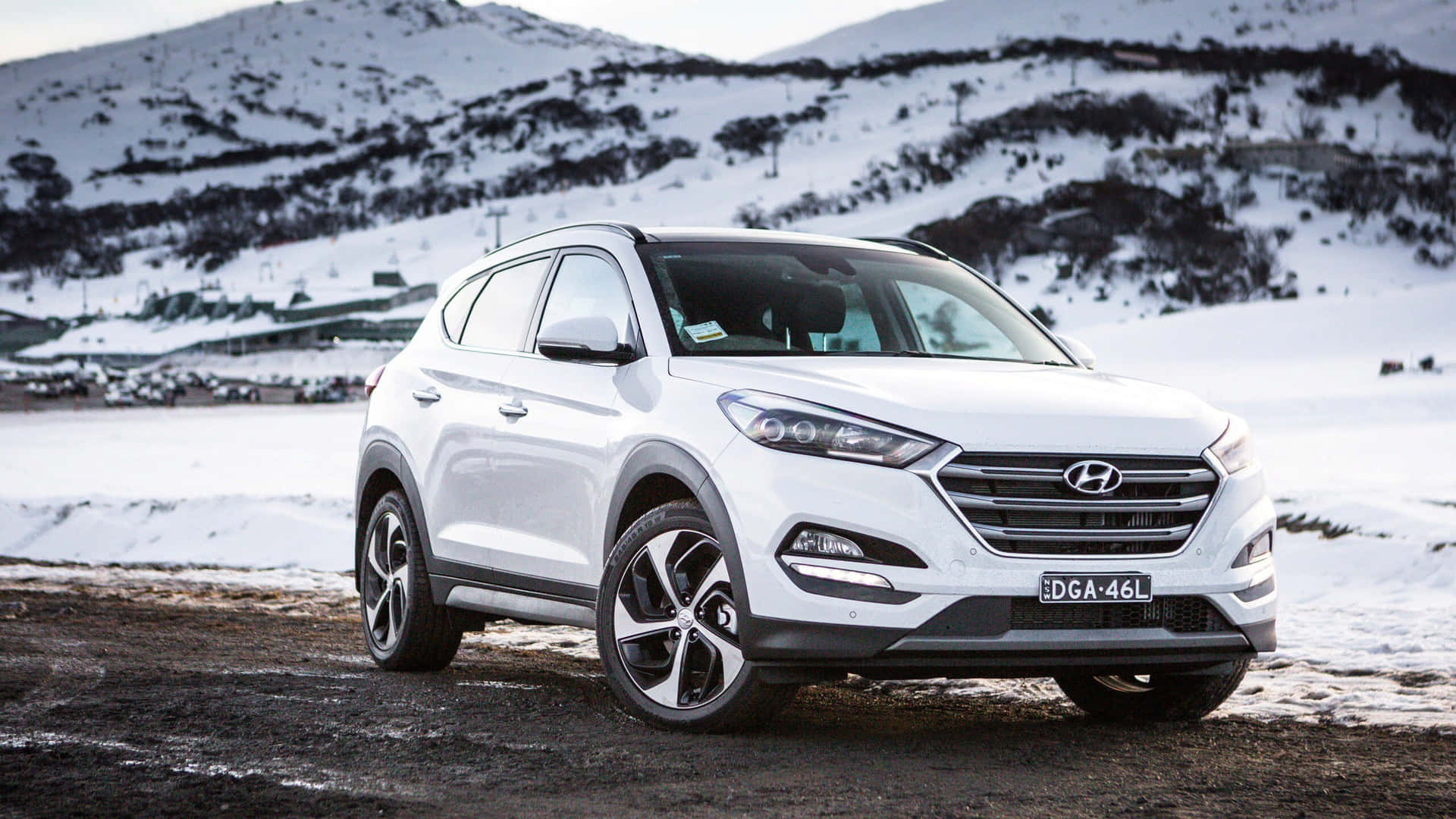 A White Hyundai Tucson Is Parked On A Snowy Road