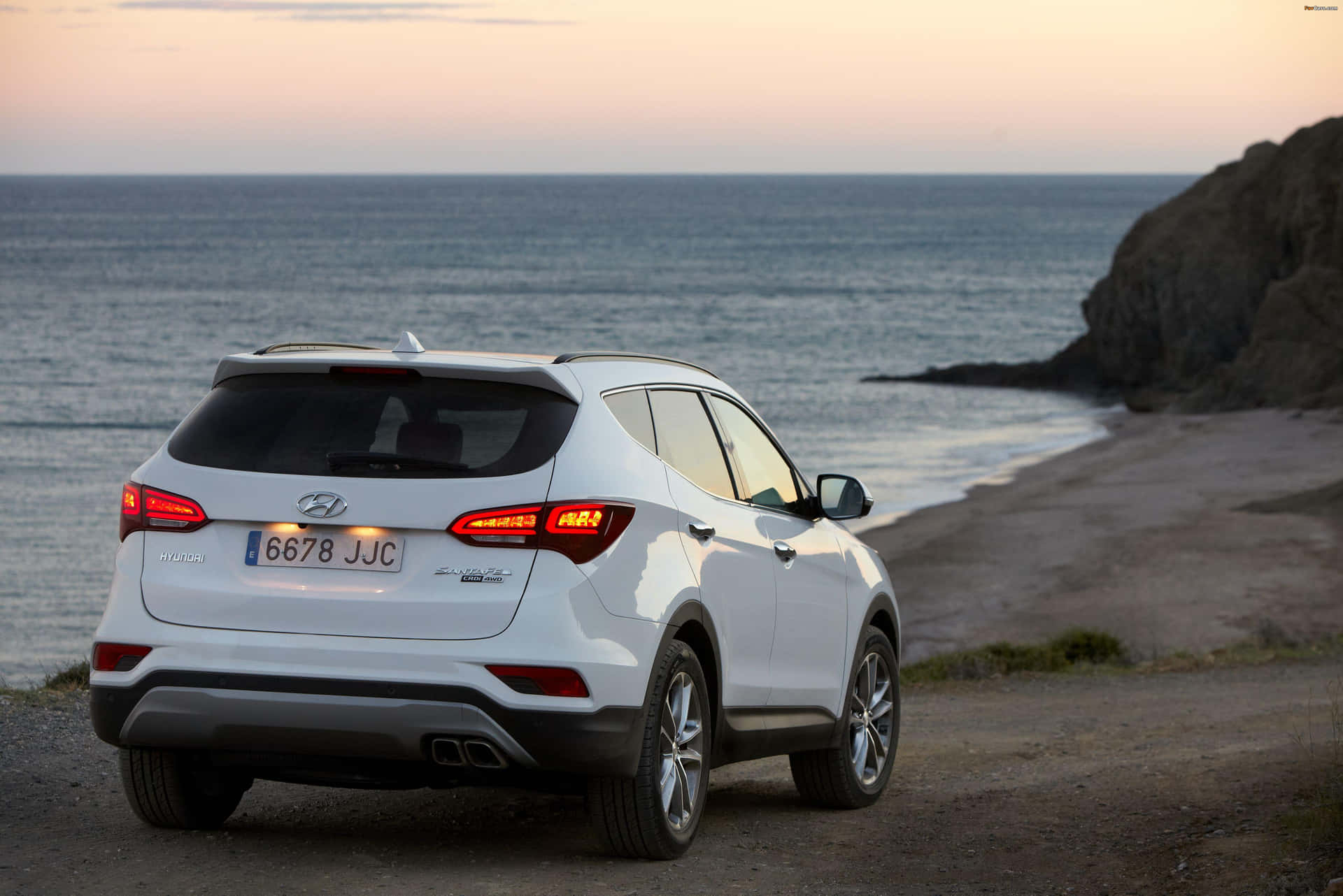 Sleek Hyundai Santa Fe driving through a scenic landscape Wallpaper