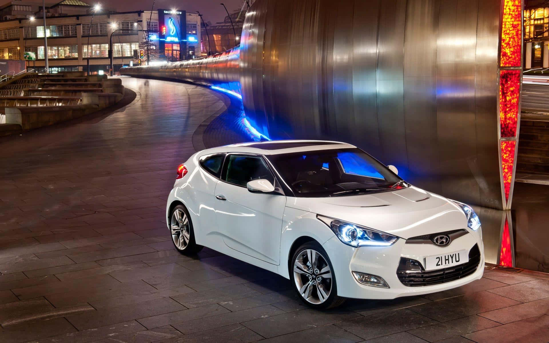 Sleek Hyundai Veloster in a cityscape at dusk Wallpaper