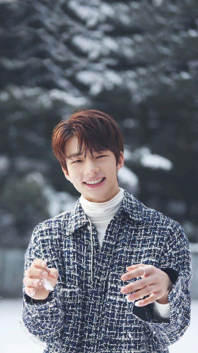 South Korean Rapper Hyunjin Against Snowy Trees Wallpaper