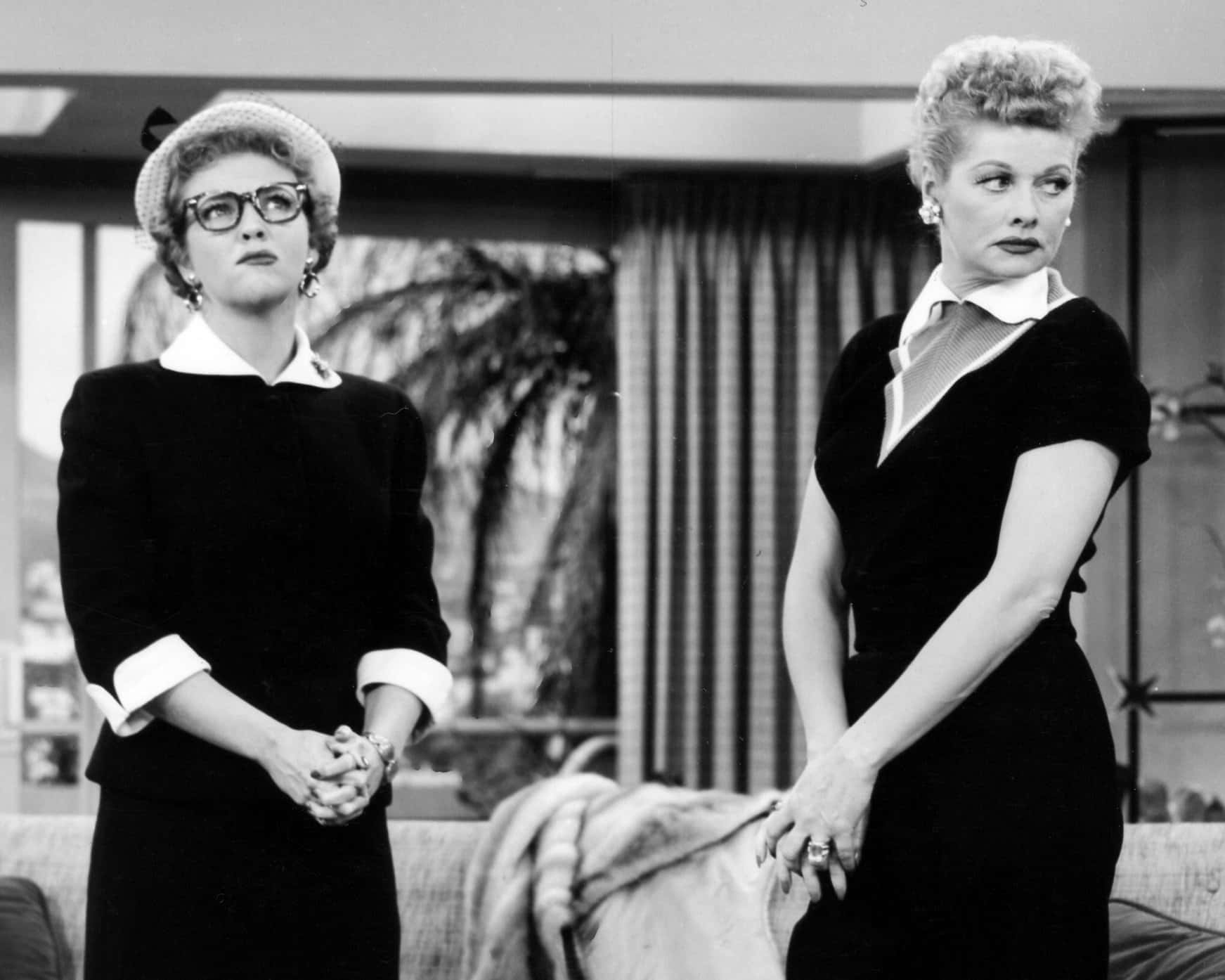 Two Women In Black And White Standing Next To Each Other Wallpaper