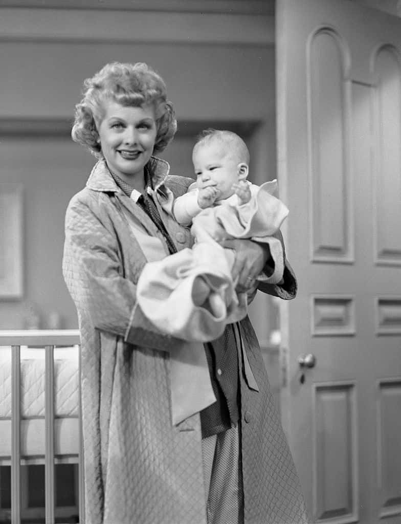 A Woman Holding A Baby In A Coat Wallpaper