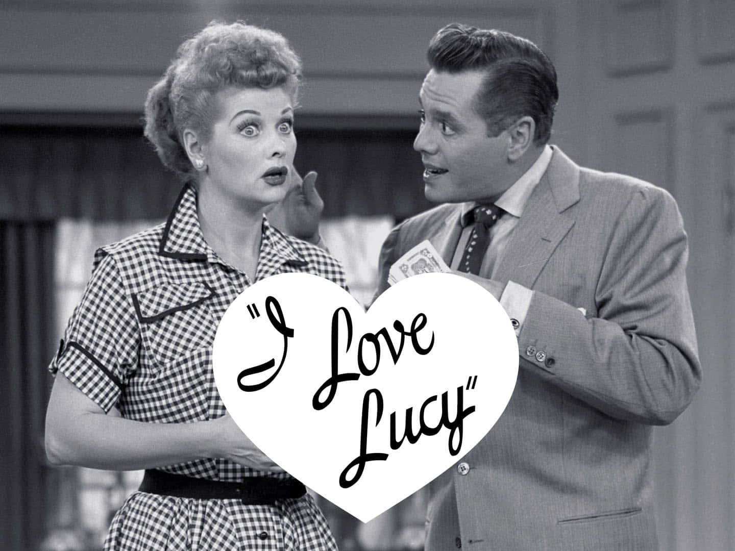 A Man And Woman Holding A Sign That Says I Love Lucy Wallpaper