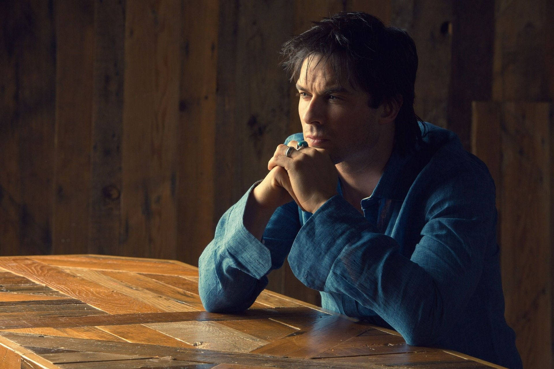 Ian Somerhalder At Wooden Table Pose Background