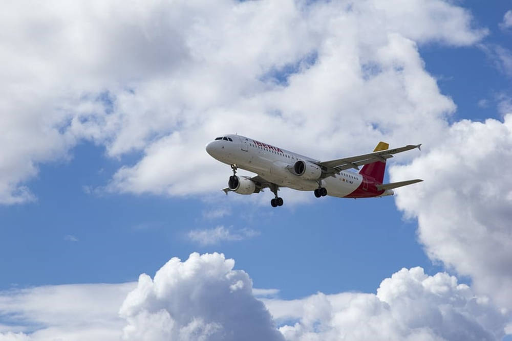 Iberia Airlines Airplane Emerging From Clouds Wallpaper