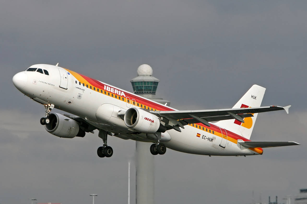 Iberia Airlines Airplane Flying By The Tower Wallpaper