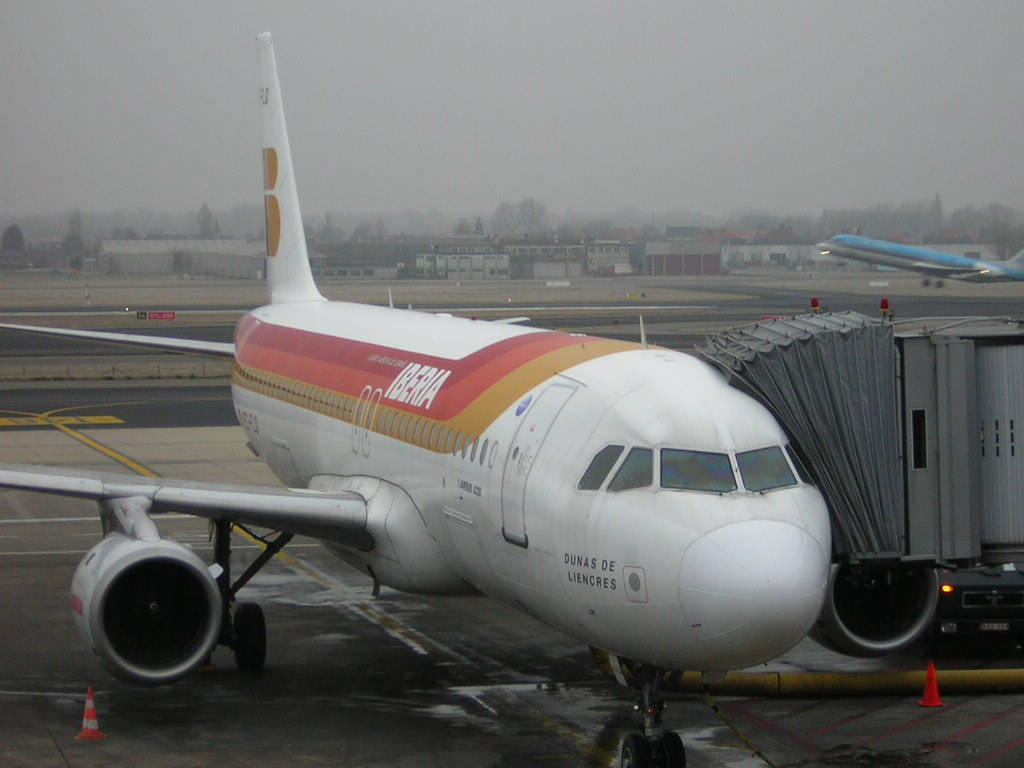 Aviónde Iberia Airlines Estacionado Con Equipamiento De Aeropuerto. Fondo de pantalla