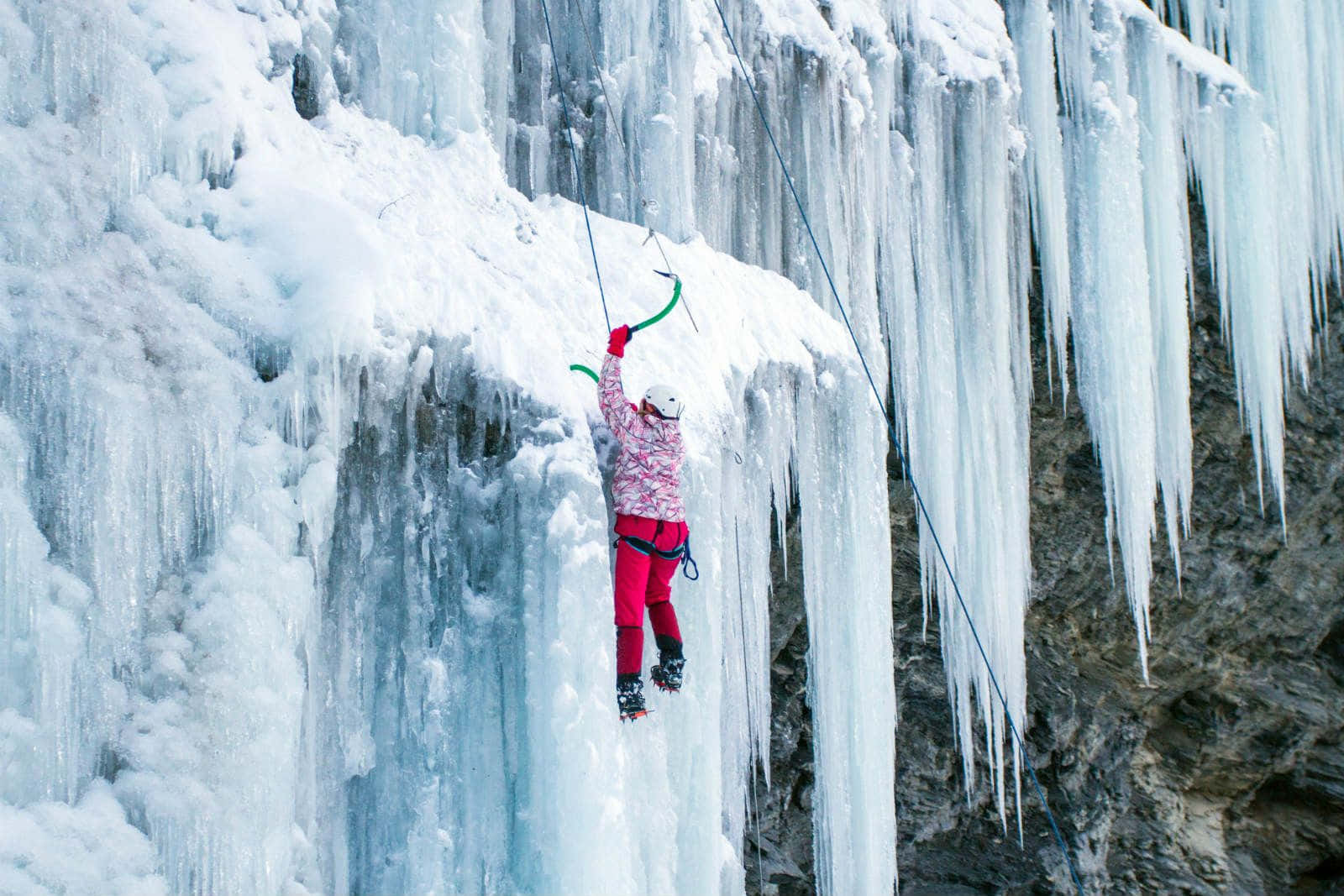 A daring ice climber conquers a frozen waterfall Wallpaper