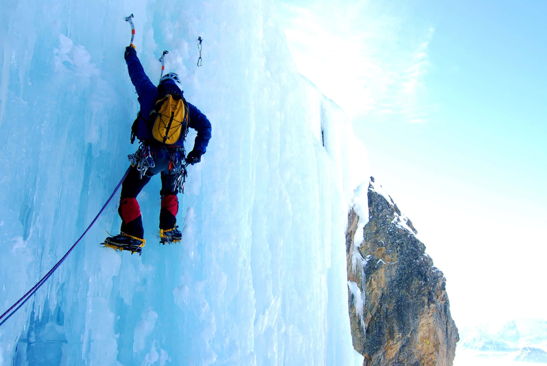 Ice climber ascending a frozen waterfall Wallpaper