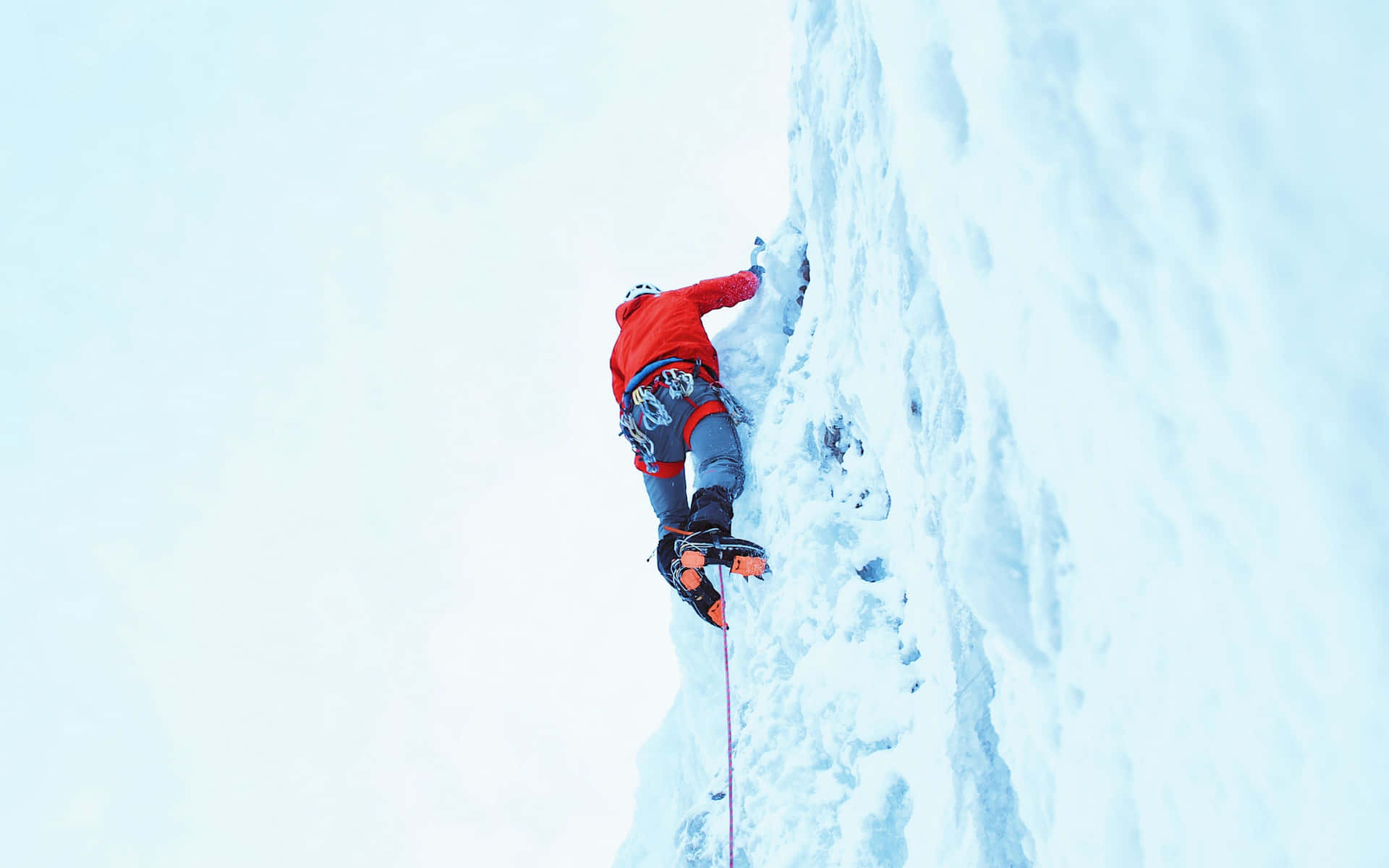 Fearless Ice Climber conquers a frozen waterfall Wallpaper