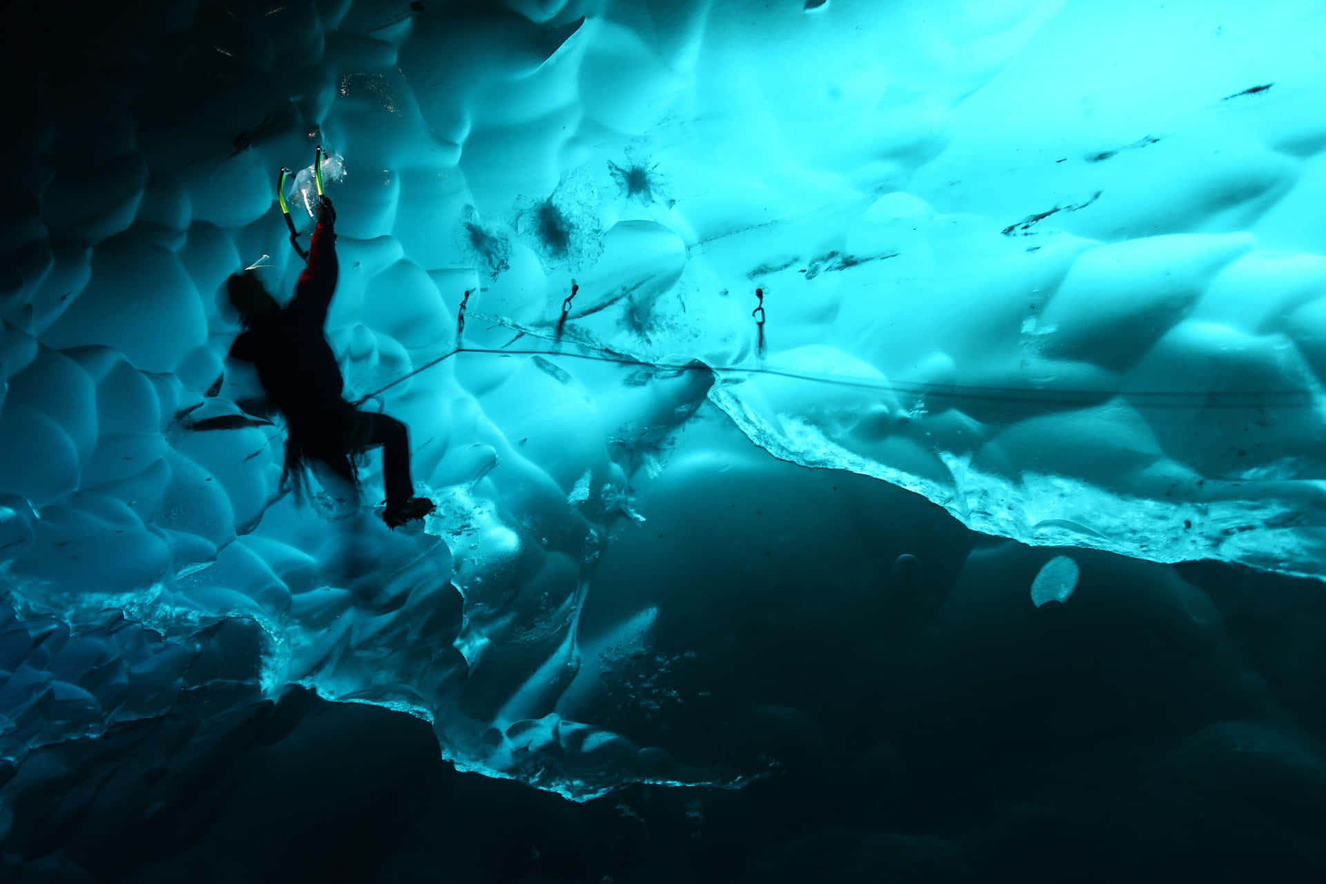 Adventurous Ice Climber Scaling a Frozen Waterfall Wallpaper