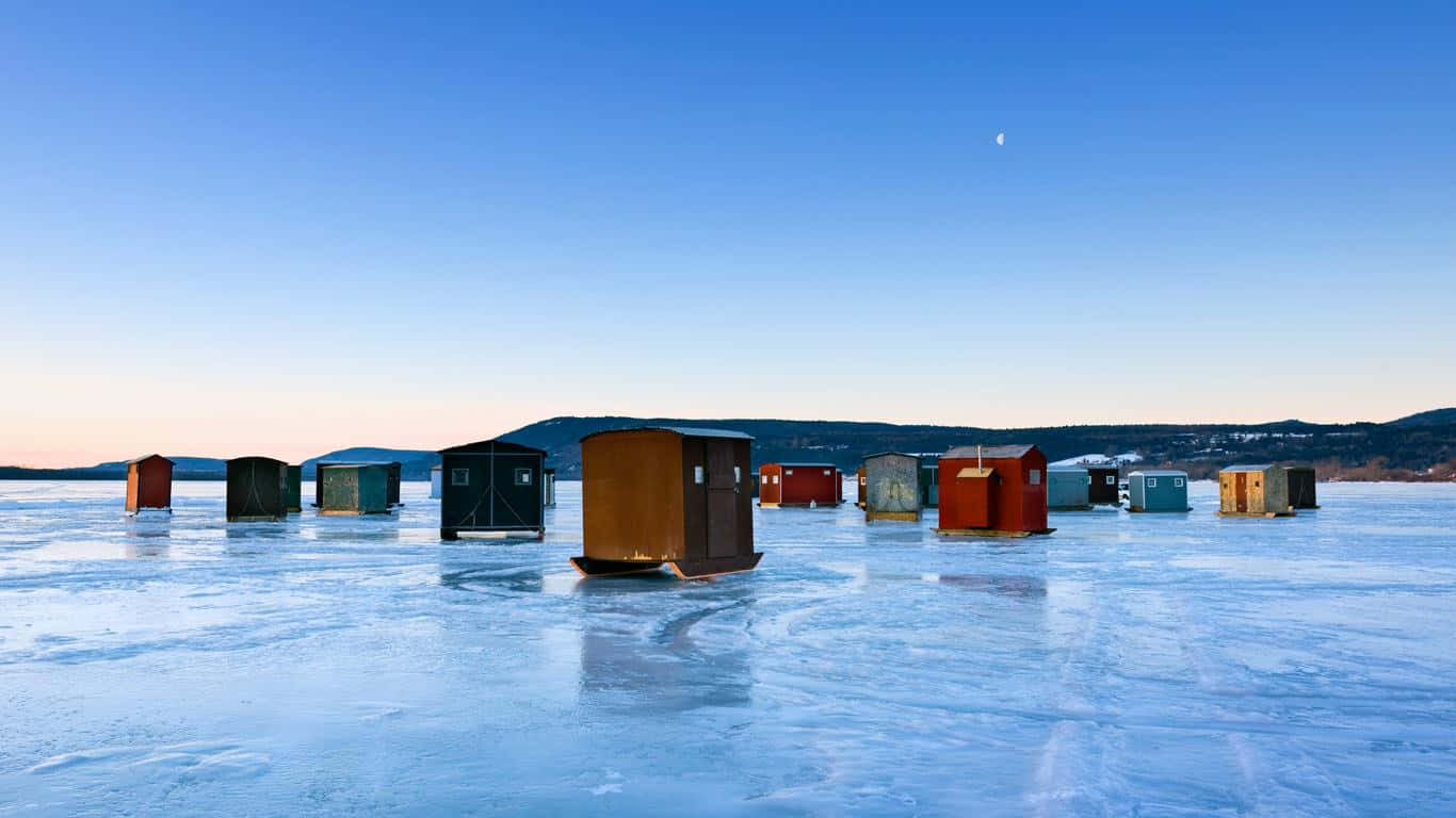 Serene Ice Fishing Experience on a Frozen Lake Wallpaper