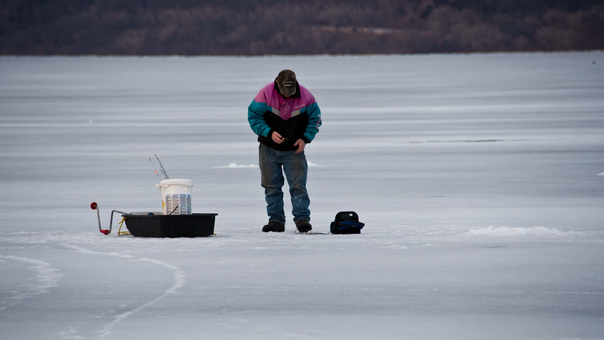 A Serene Ice Fishing Getaway on a Frozen Lake Wallpaper