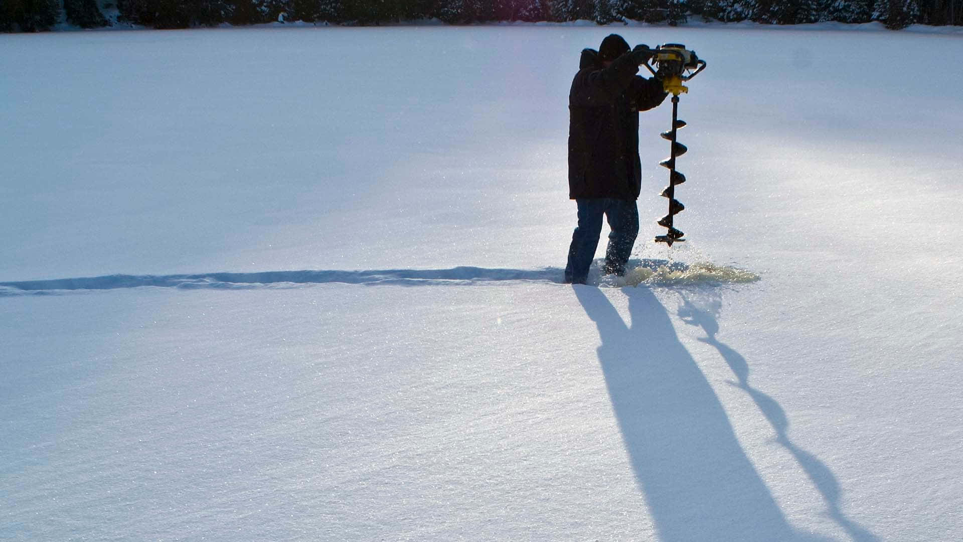 A tranquil ice fishing experience on a frozen lake Wallpaper