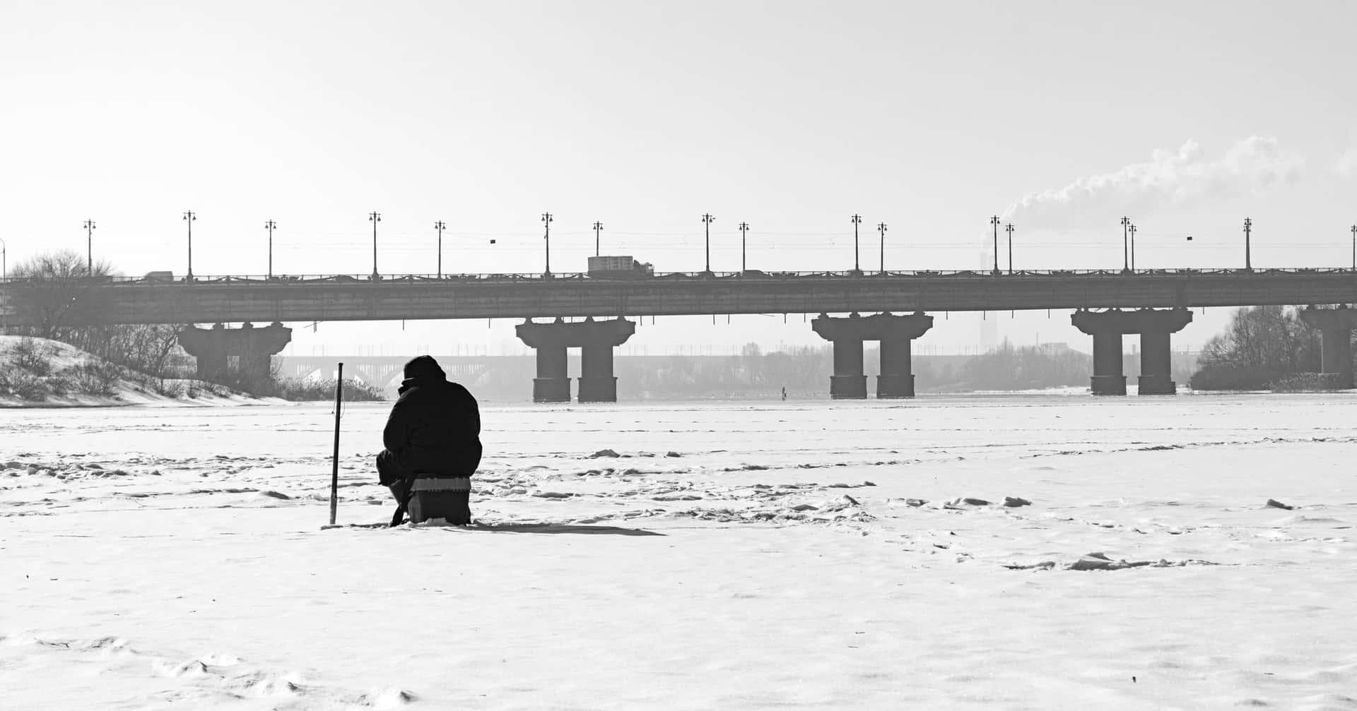 A group of friends enjoying ice fishing on a frozen lake Wallpaper