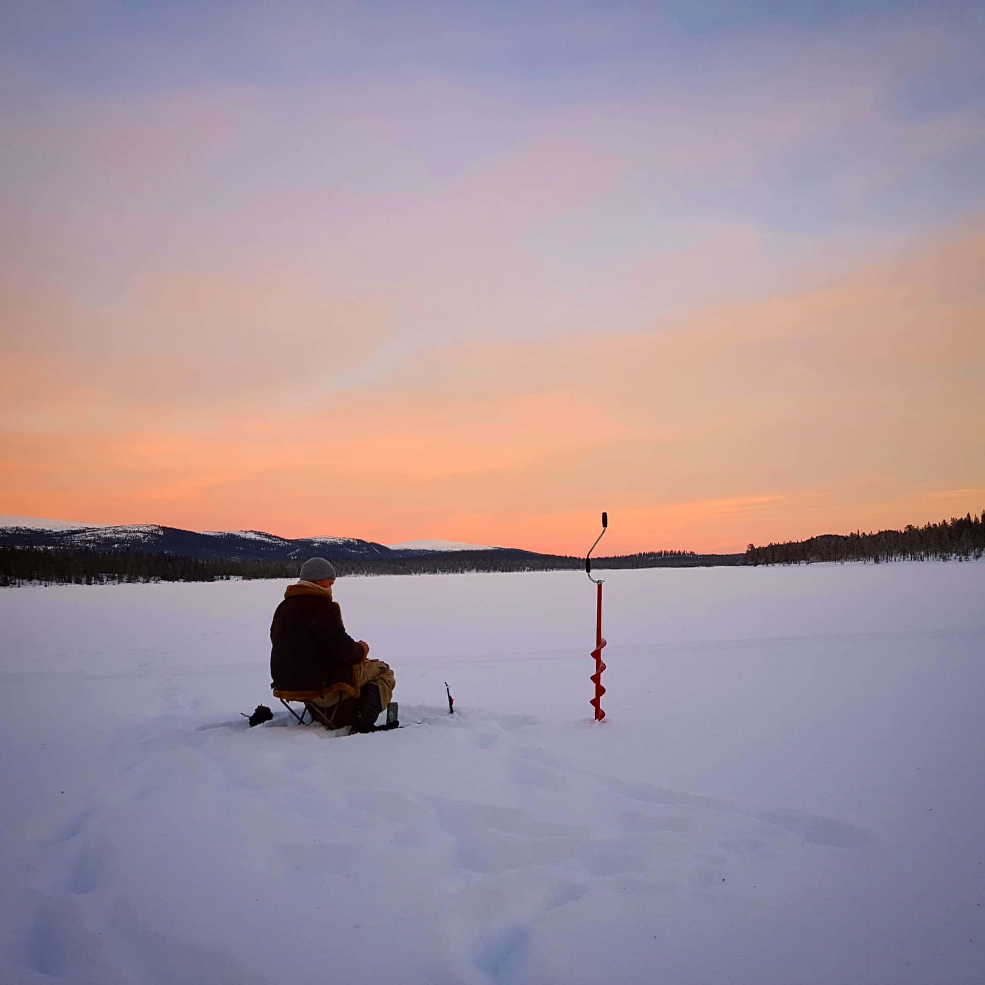 Serene ice fishing scene on a frozen lake Wallpaper