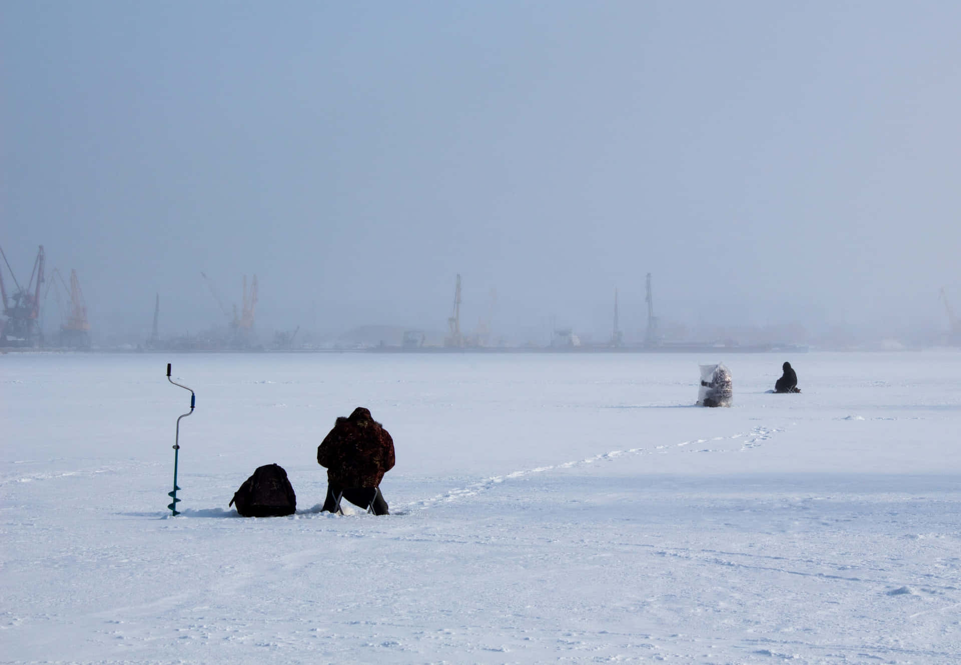 Ungrupo De Entusiastas De La Pesca En Hielo En Un Lago Congelado Fondo de pantalla