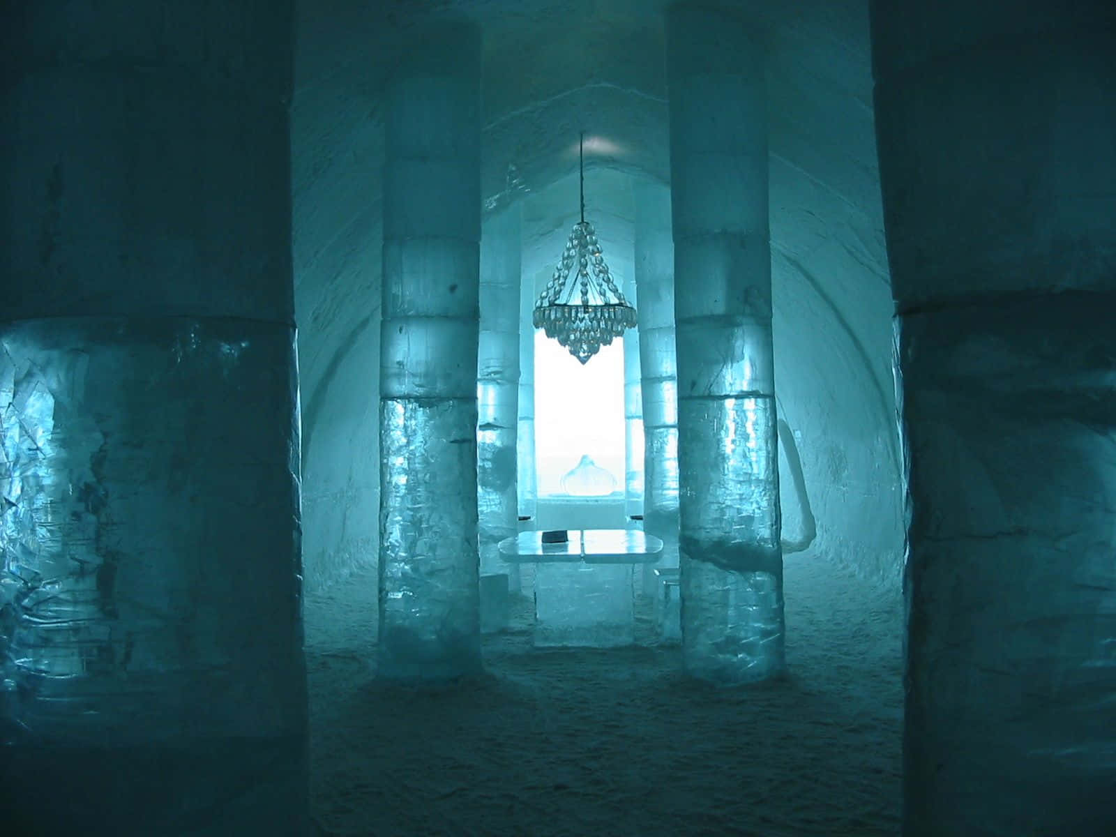A mesmerizing view of the Ice Hotel with intricate ice sculptures in the heart of winter Wallpaper