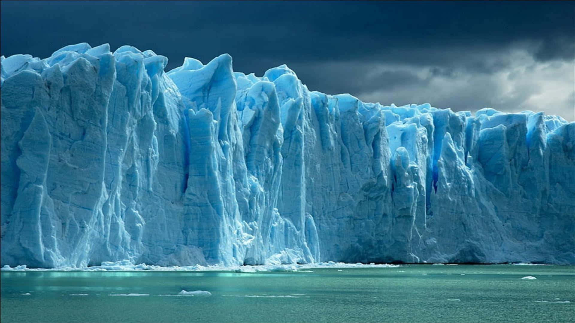 Stunning Iceberg Floating on Crystalline Blue Waters Wallpaper