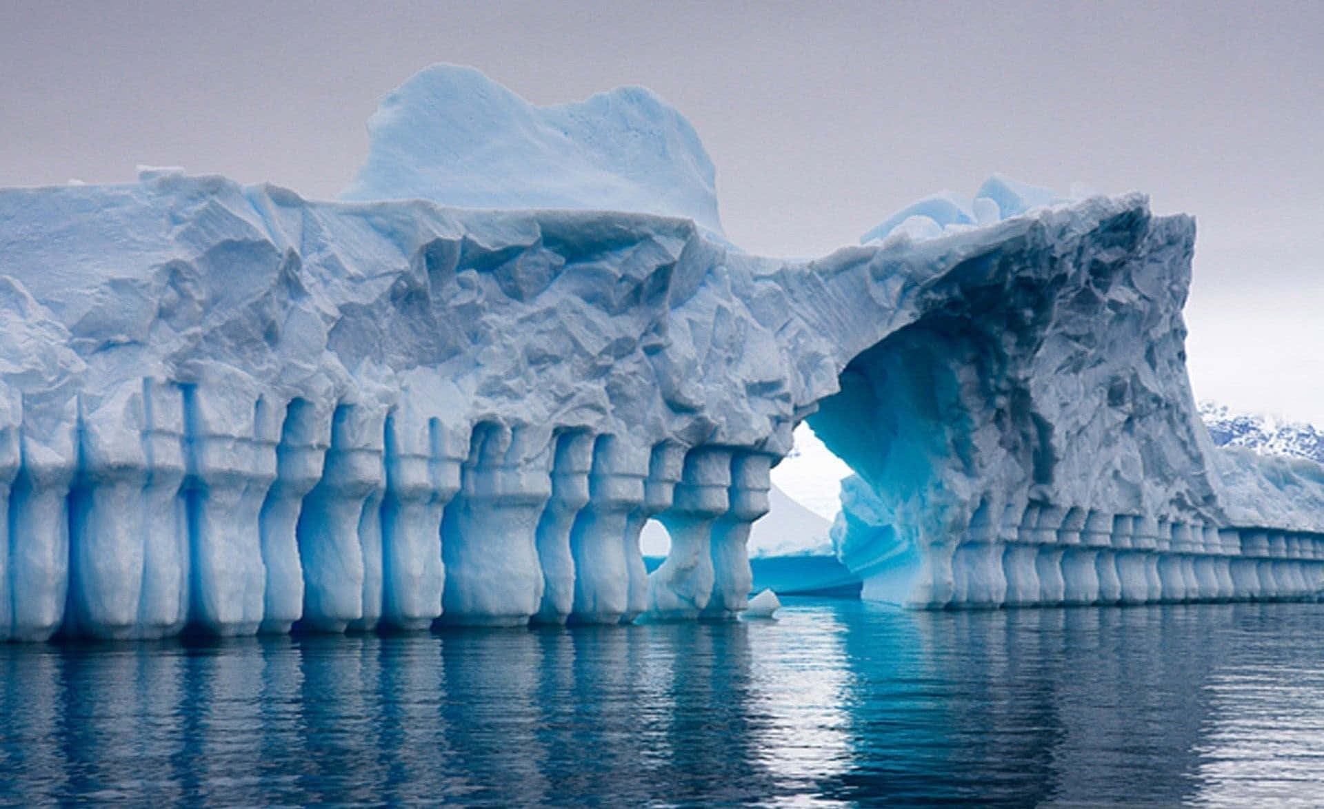 Majestic Iceberg Floating on Tranquil Waters Wallpaper