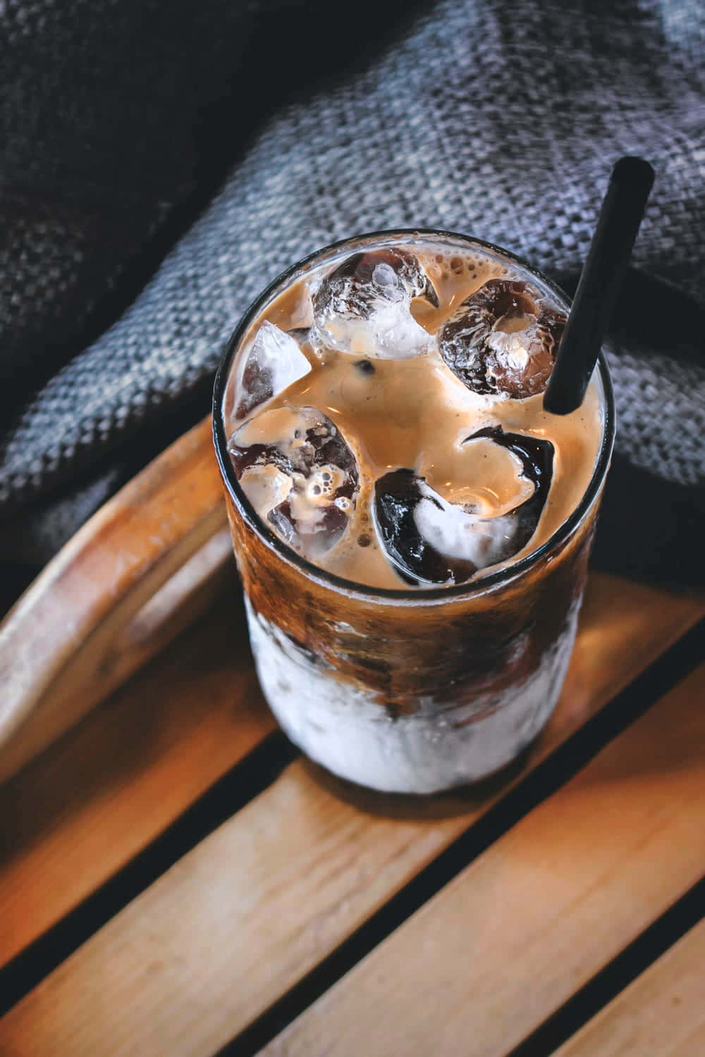 A Cup Of Coffee With Ice And A Straw