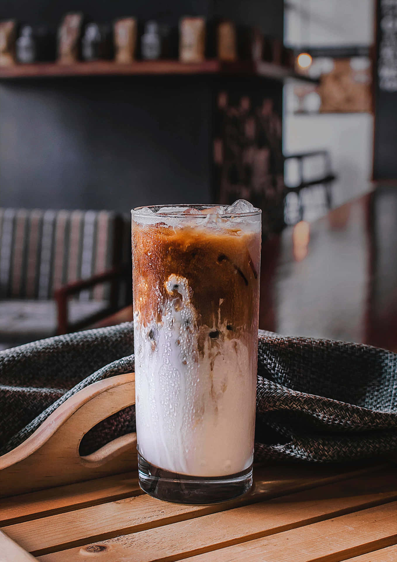 A Glass Of Iced Coffee Sitting On A Wooden Table
