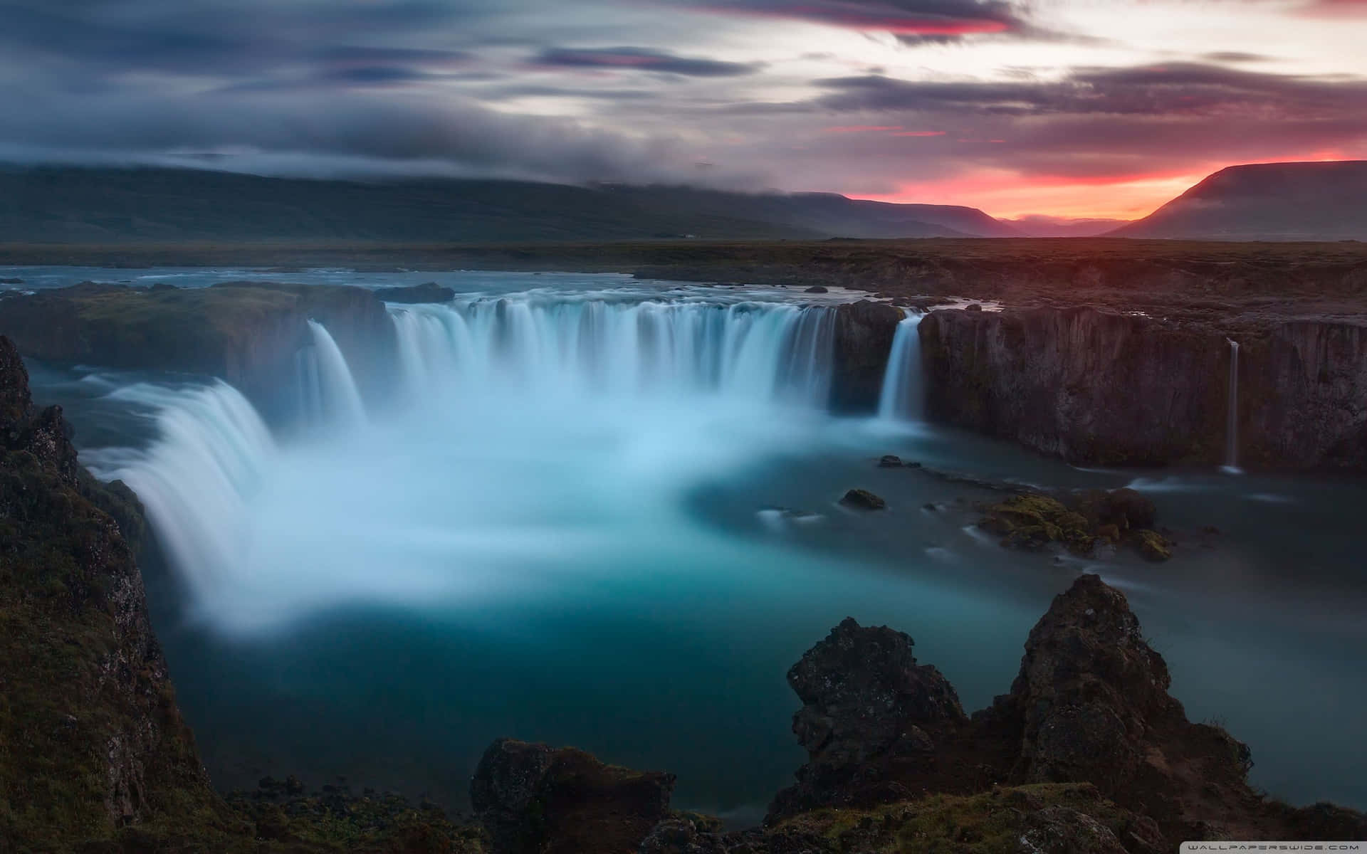A Waterfall At Sunset In Iceland Wallpaper