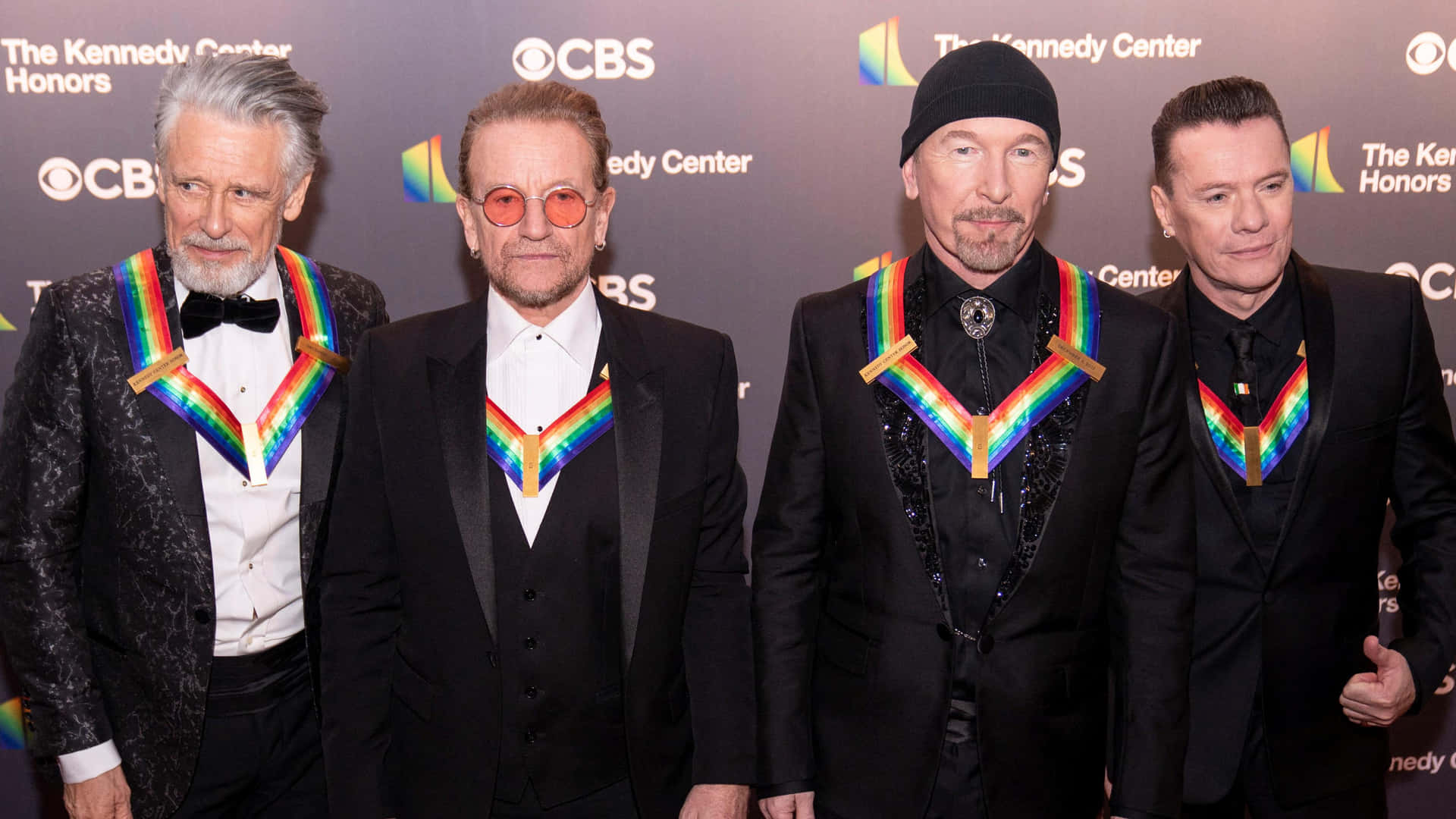 Download Iconic Band Members Rainbow Accents Event Wallpaper ...