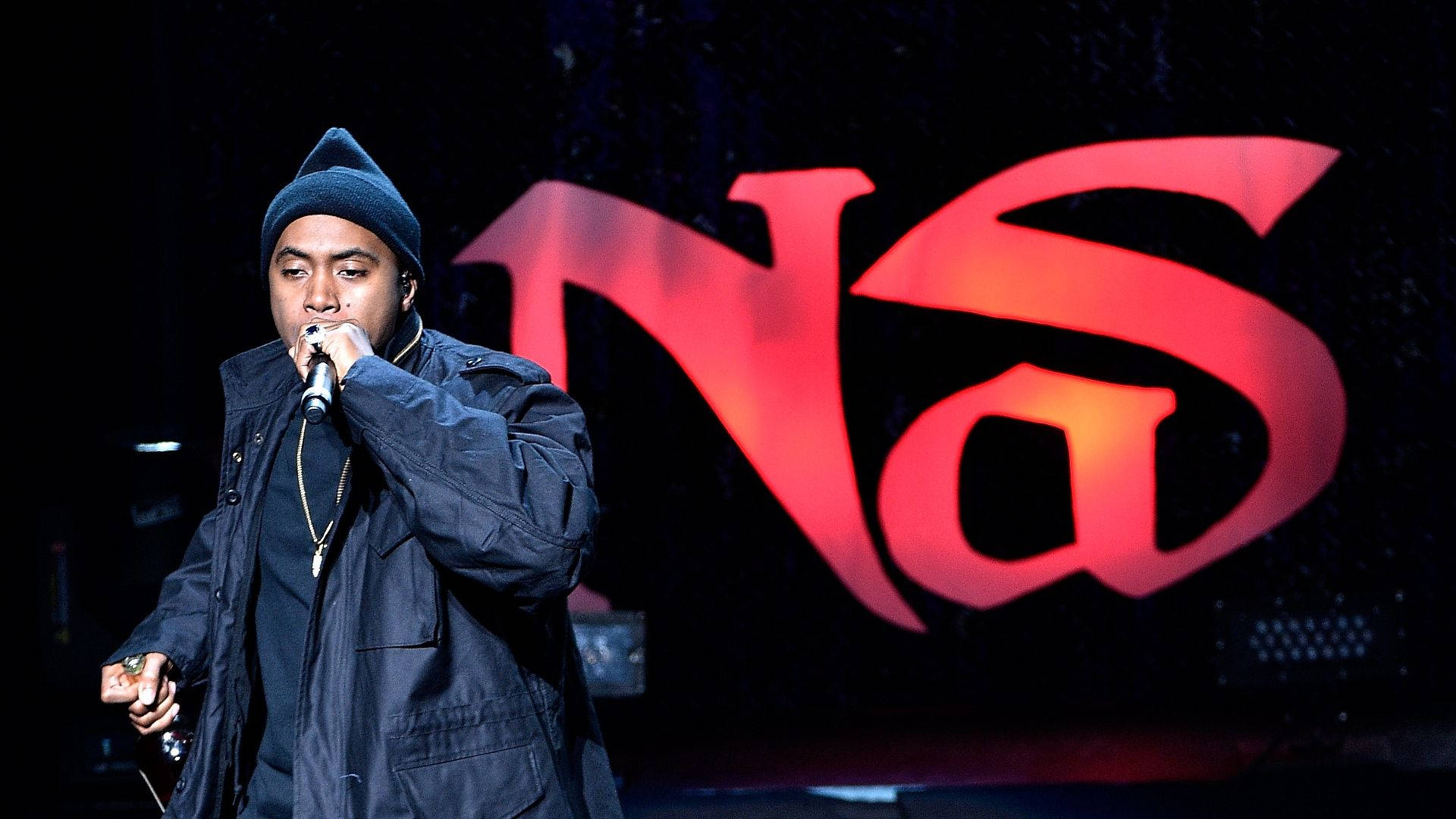 The legendary rapper Nas delivering a powerful performance onstage Wallpaper