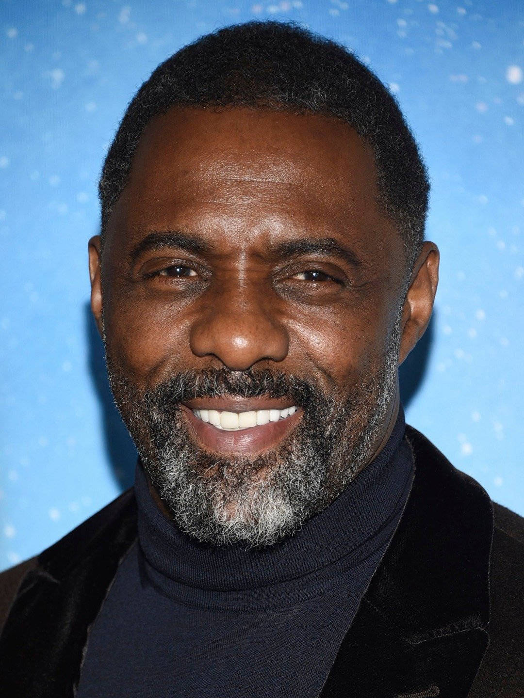 Idris Elba Against Blue With Snow-like Graphics Wallpaper