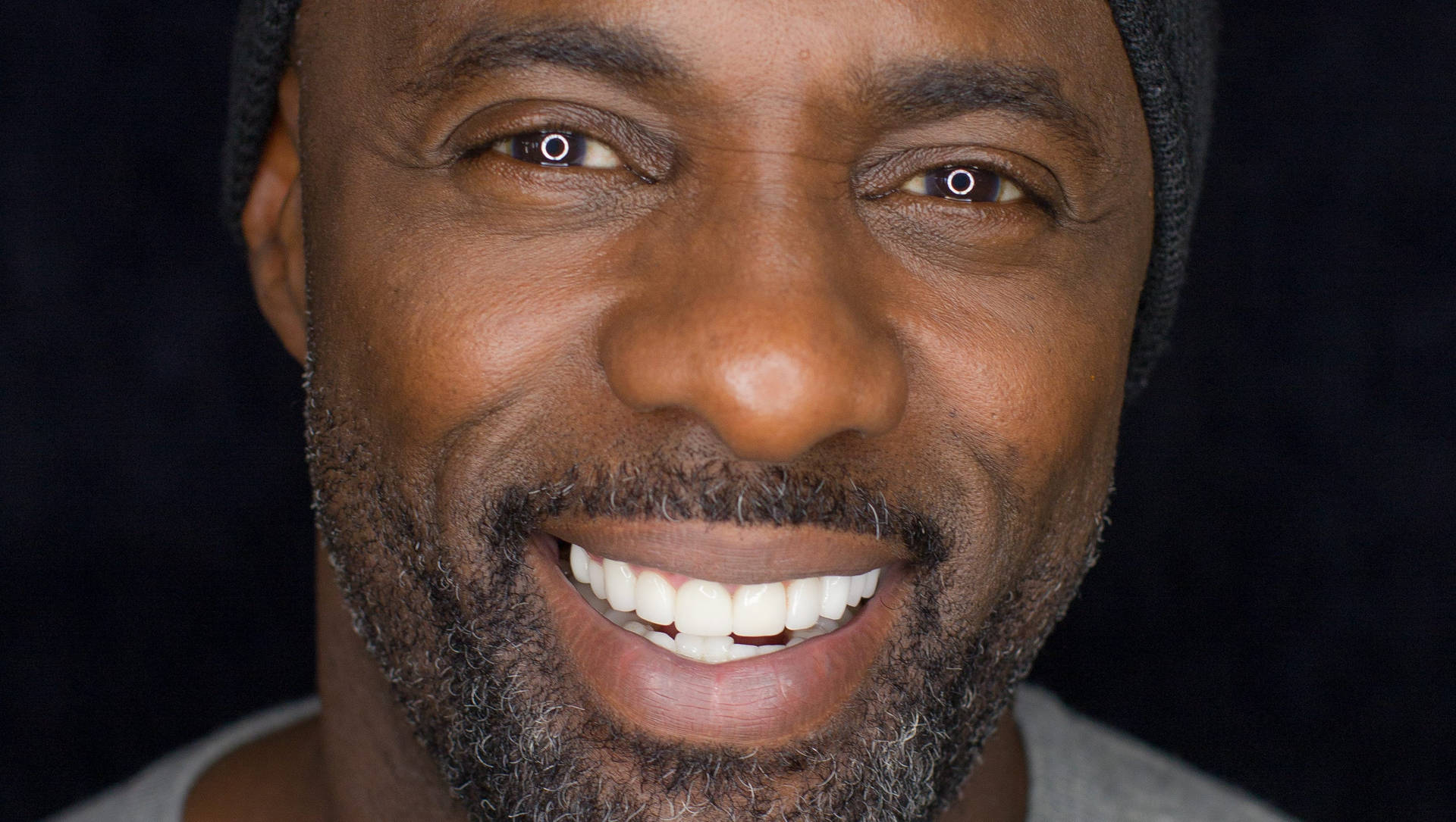Idris Elba Smiling With Teeth Wallpaper