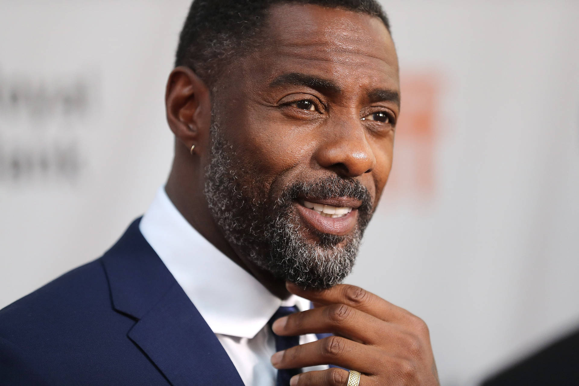 Idris Elba Touching Tie Of His Suit Wallpaper