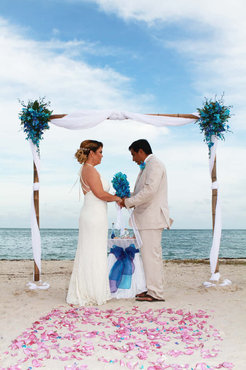Idyllic Beach Wedding With Sunset Backdrop Wallpaper