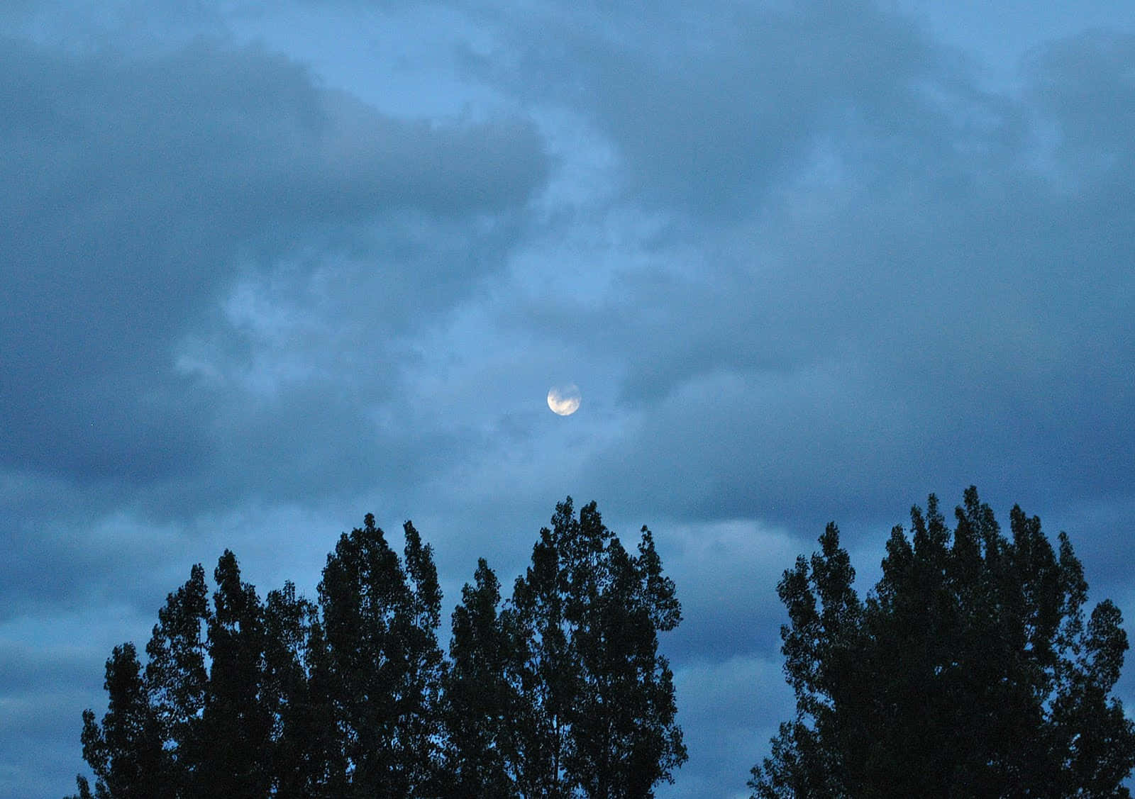 Illuminated Waning Gibbous Moon Against Dark Sky Wallpaper