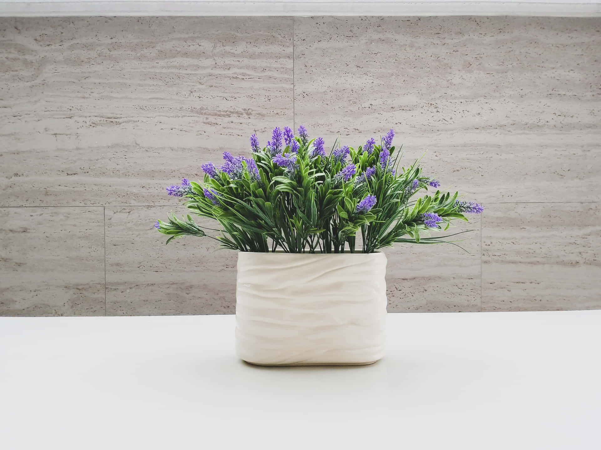 a white vase with purple flowers