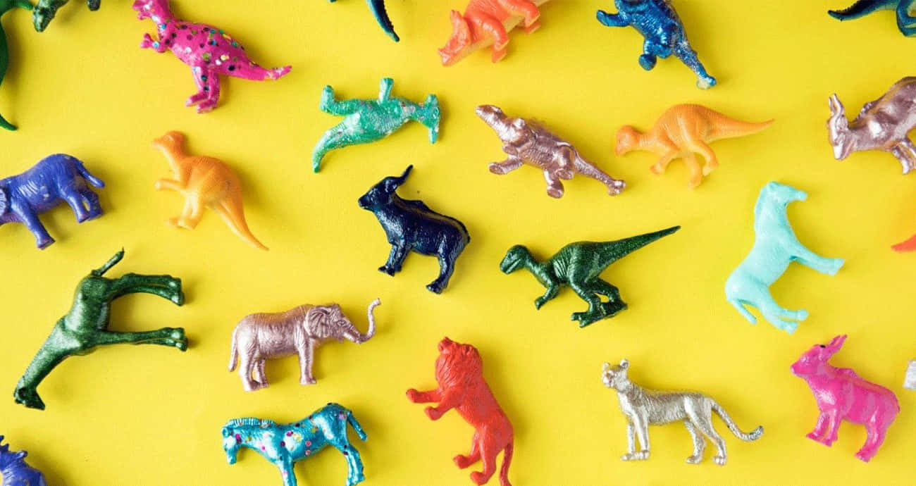 A vibrant display of inclusive zoo animal toys gathered on a small wooden table. Wallpaper