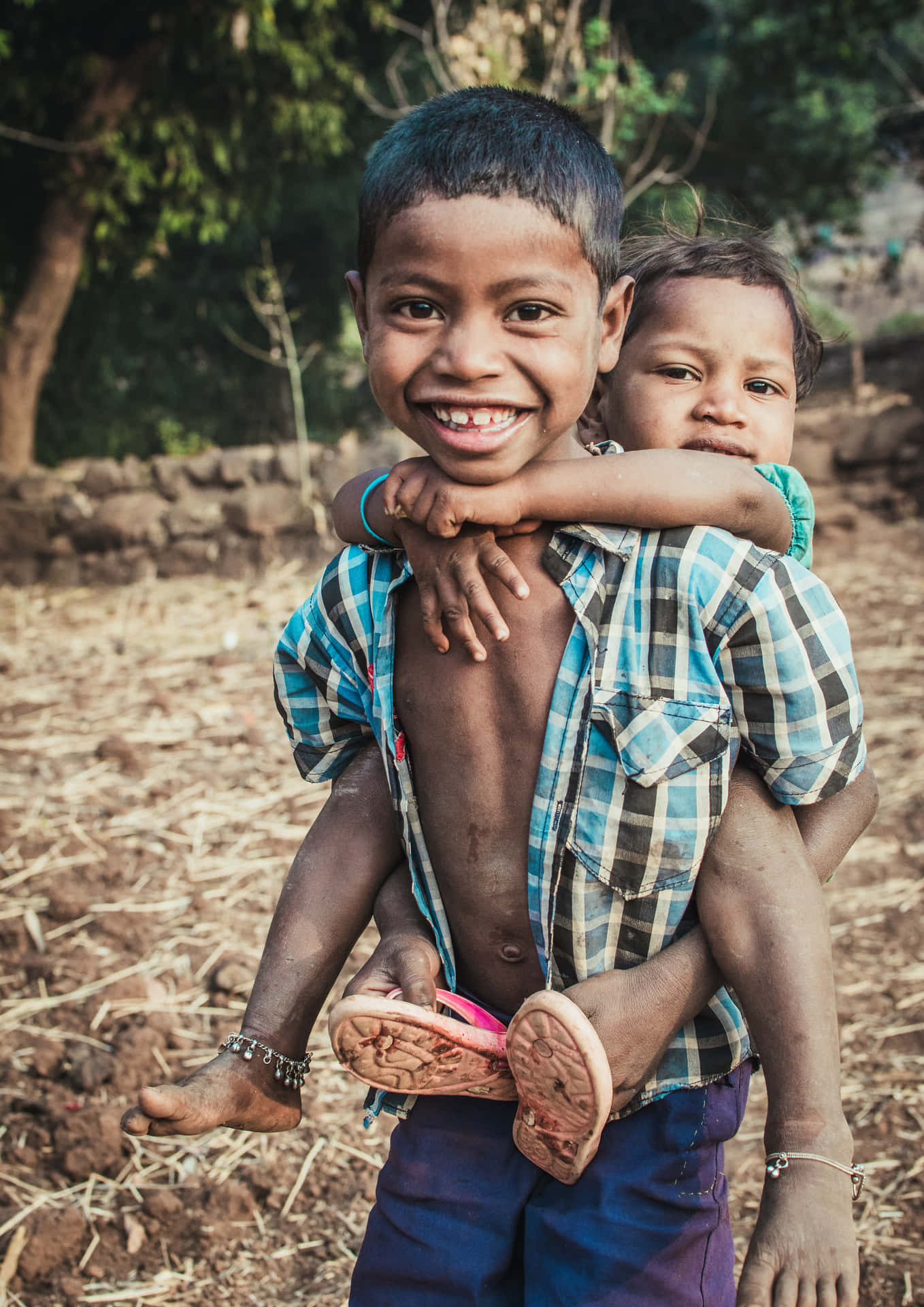Young Indian Boy Carrying His Brother Picture