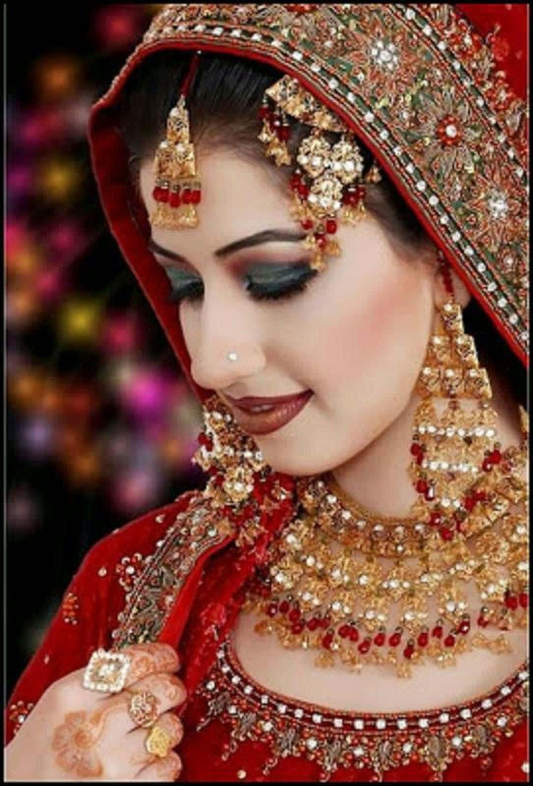 Indischebraut In Rotem Kleid Mit Goldenen Perlenbild