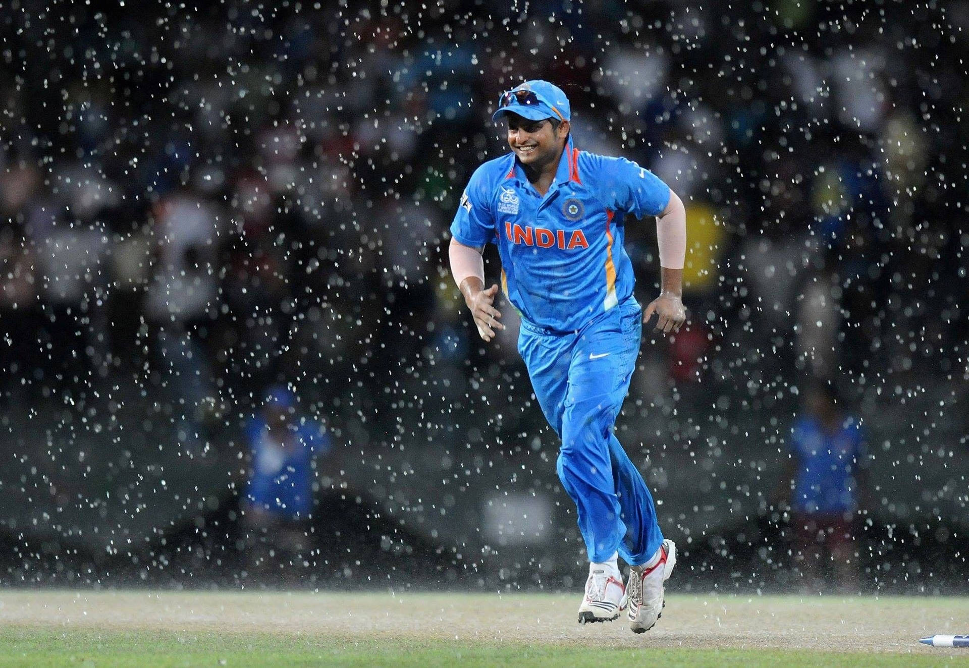 Et medlem af den indiske cricketteam løber i regnen Wallpaper