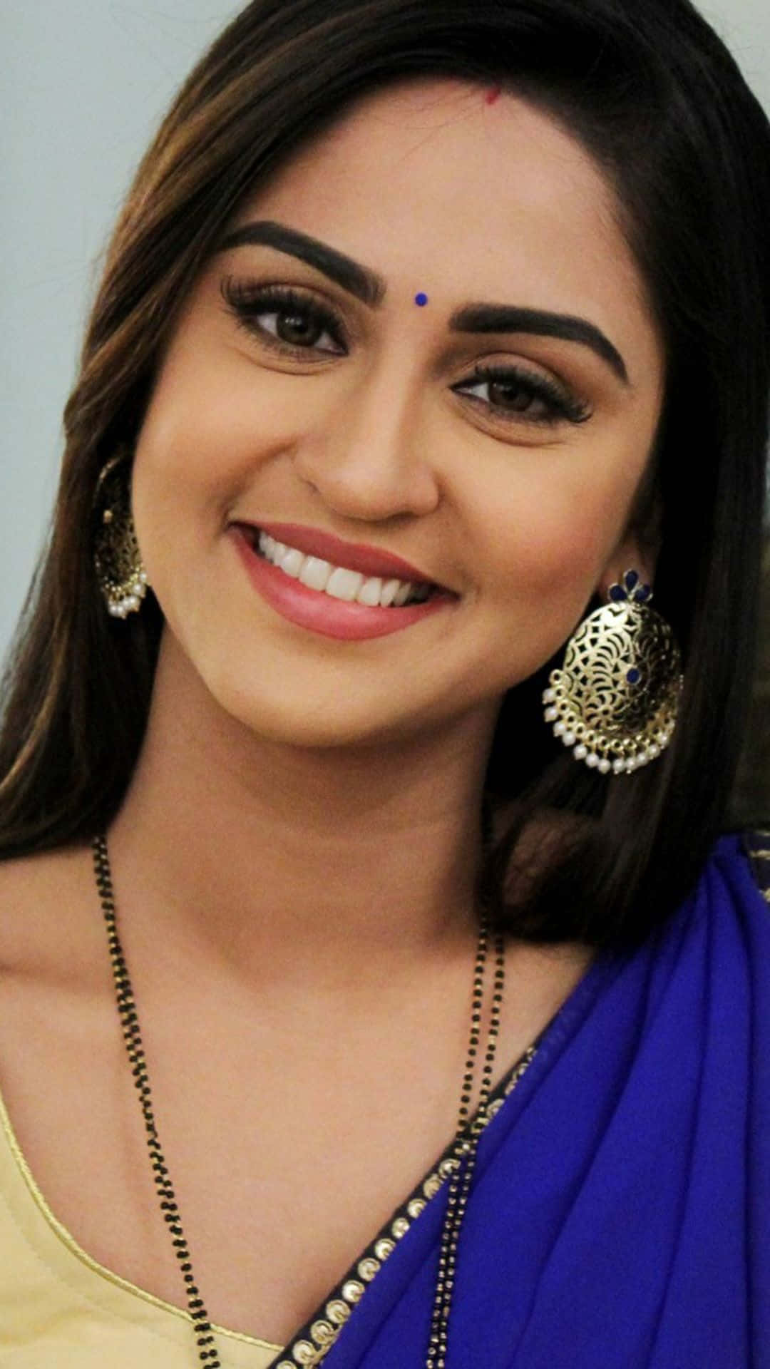 A Beautiful Woman In A Blue Sari Smiling