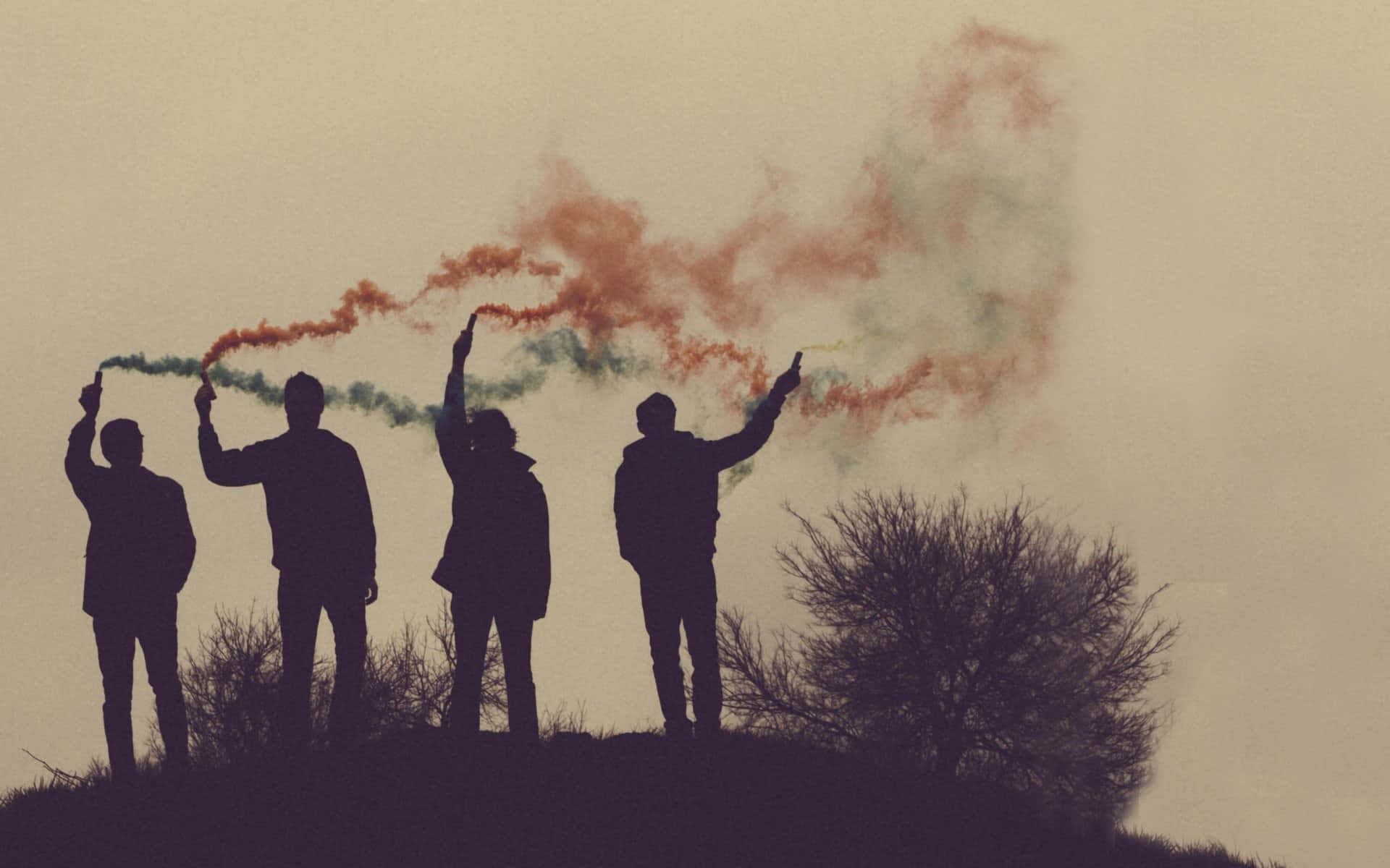 Silhouettes Of People Holding Colored Smoke